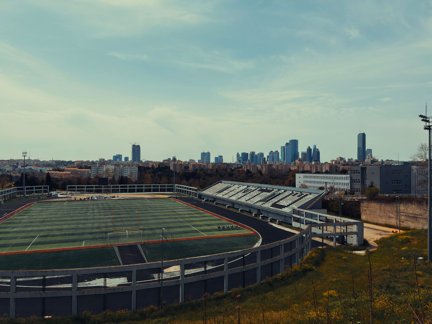 View of Istanbul's skyline with a sports field in the foreground, highlighting the city's blend of modernity and health tourism.