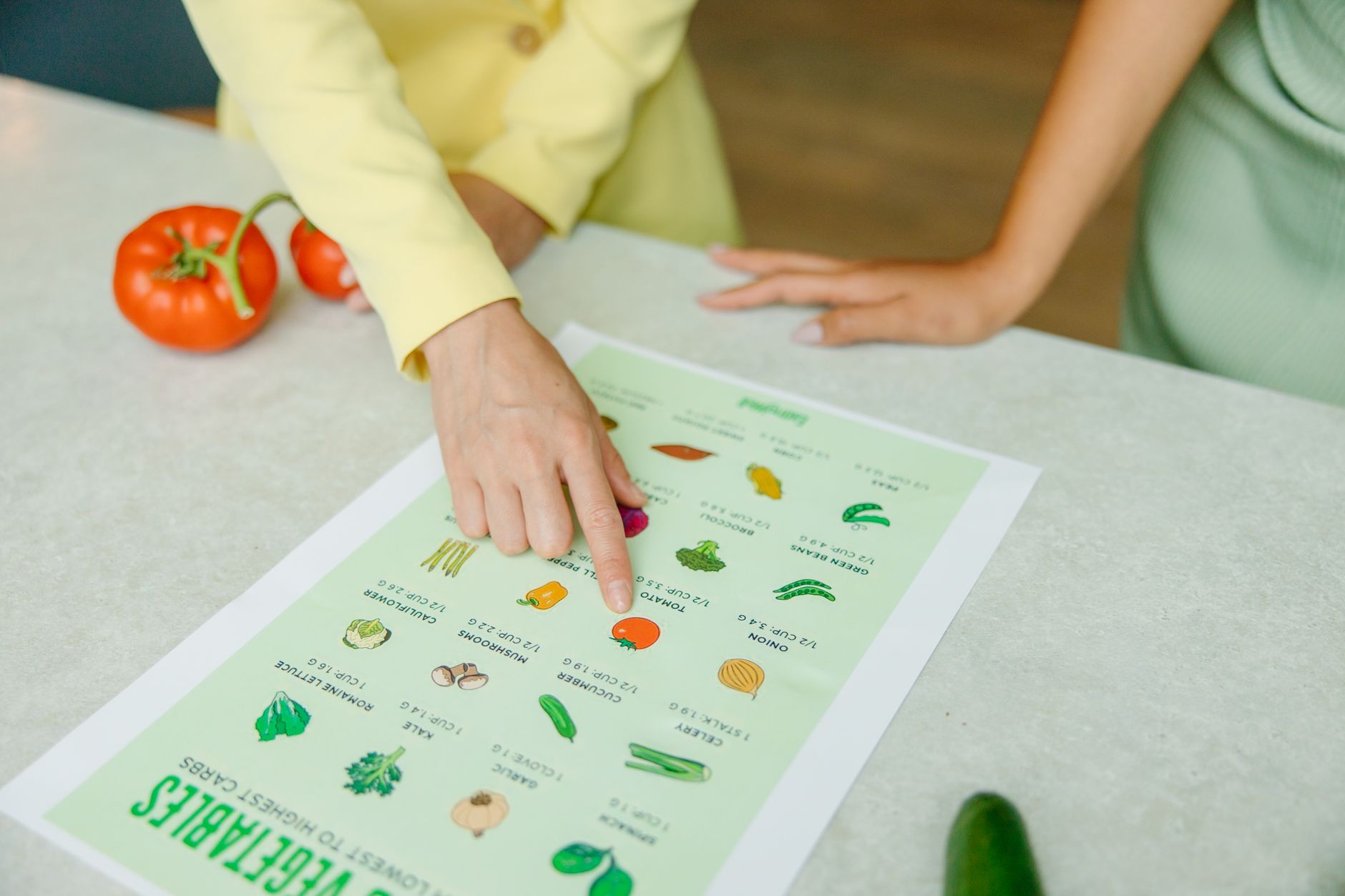 Two individuals discussing a vegetable chart during a nutritional counseling session.