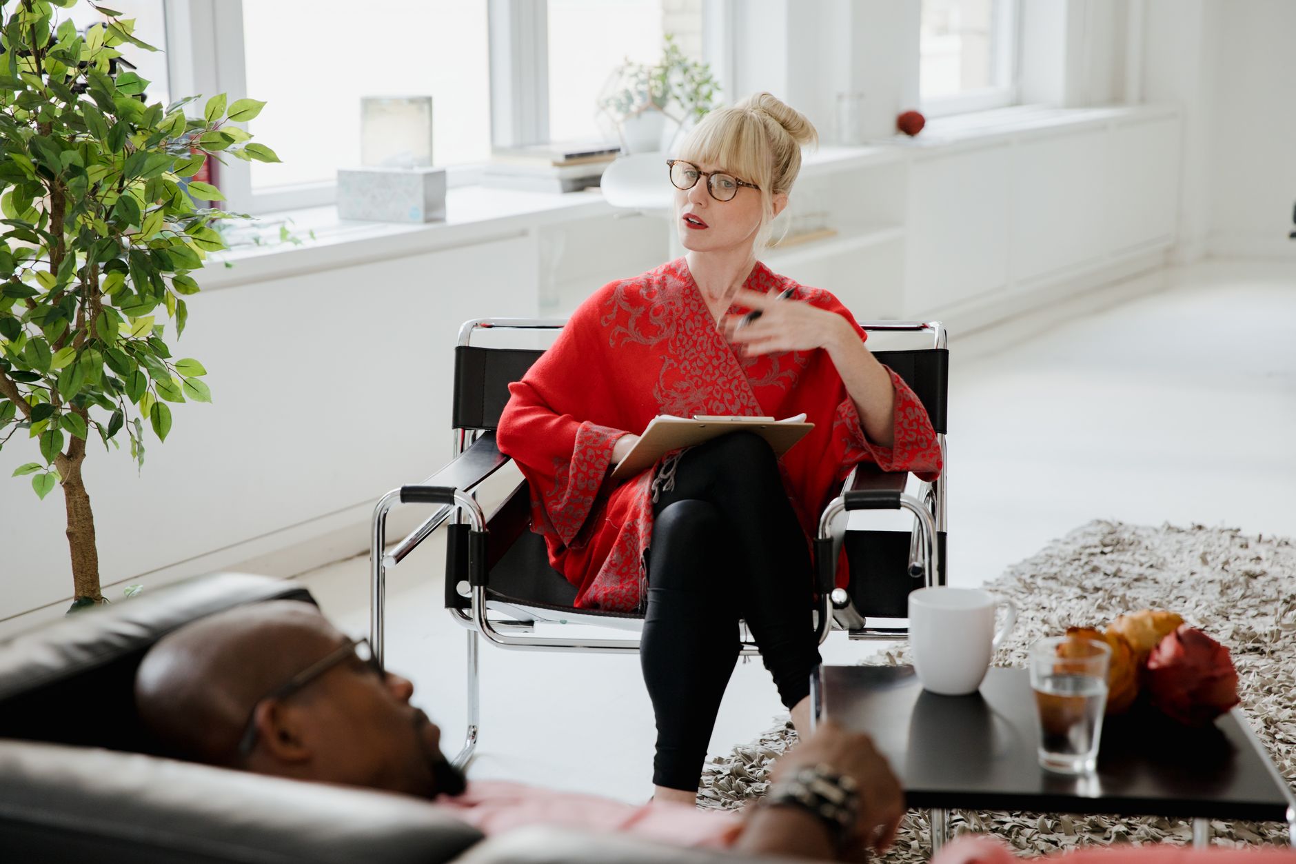 A nutritionist discusses with a bariatric patient during an aftercare support session in a bright room.