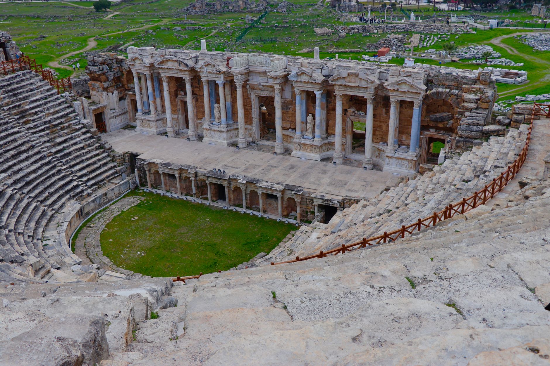 Theater ruins of Hierapolis, showcasing ancient architecture and surrounding green landscape.