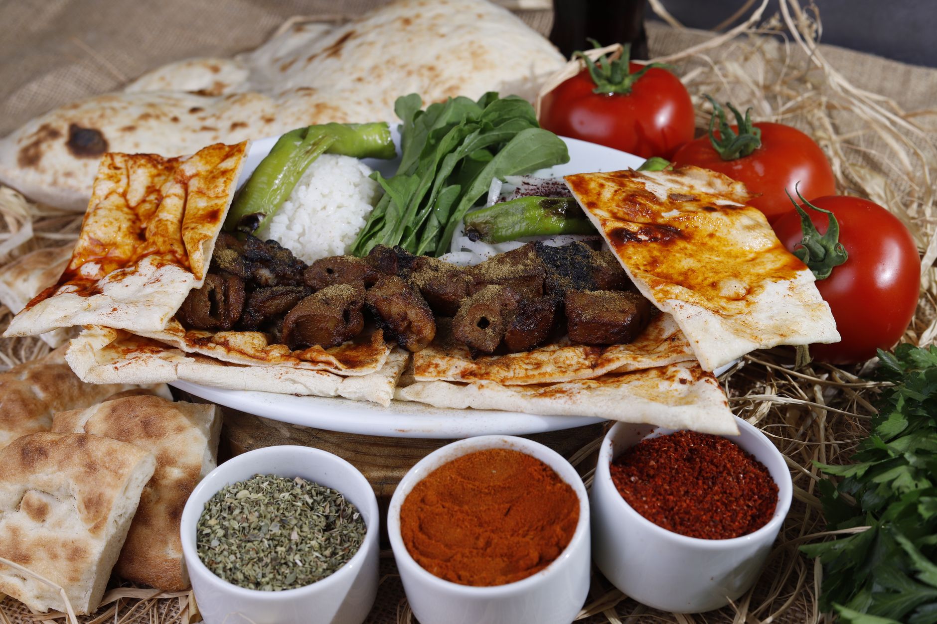 A colorful plate featuring grilled meat, rice, vegetables, and spices, representing healthy Turkish cuisine.