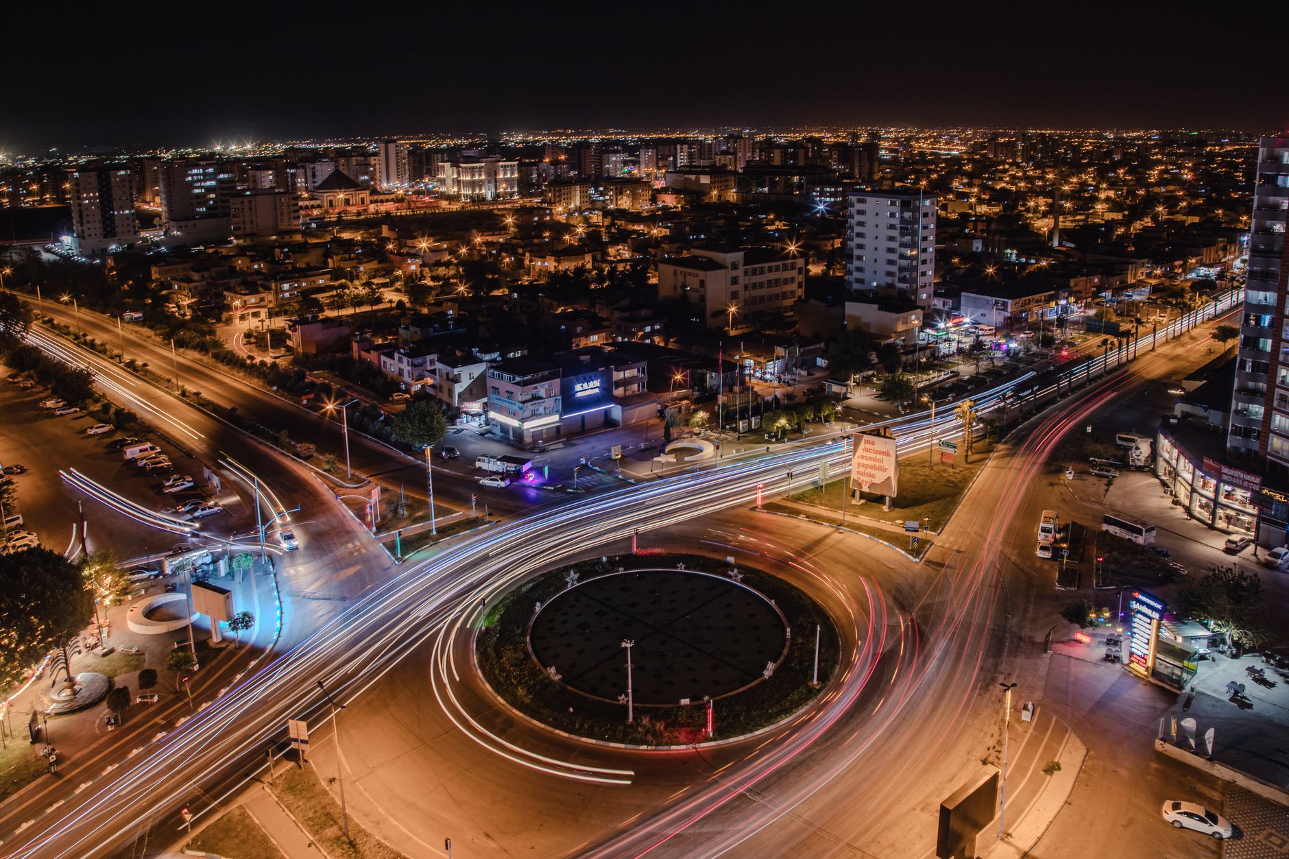 Panoramic view of Adana at night, showcasing vibrant city lights and busy roads.