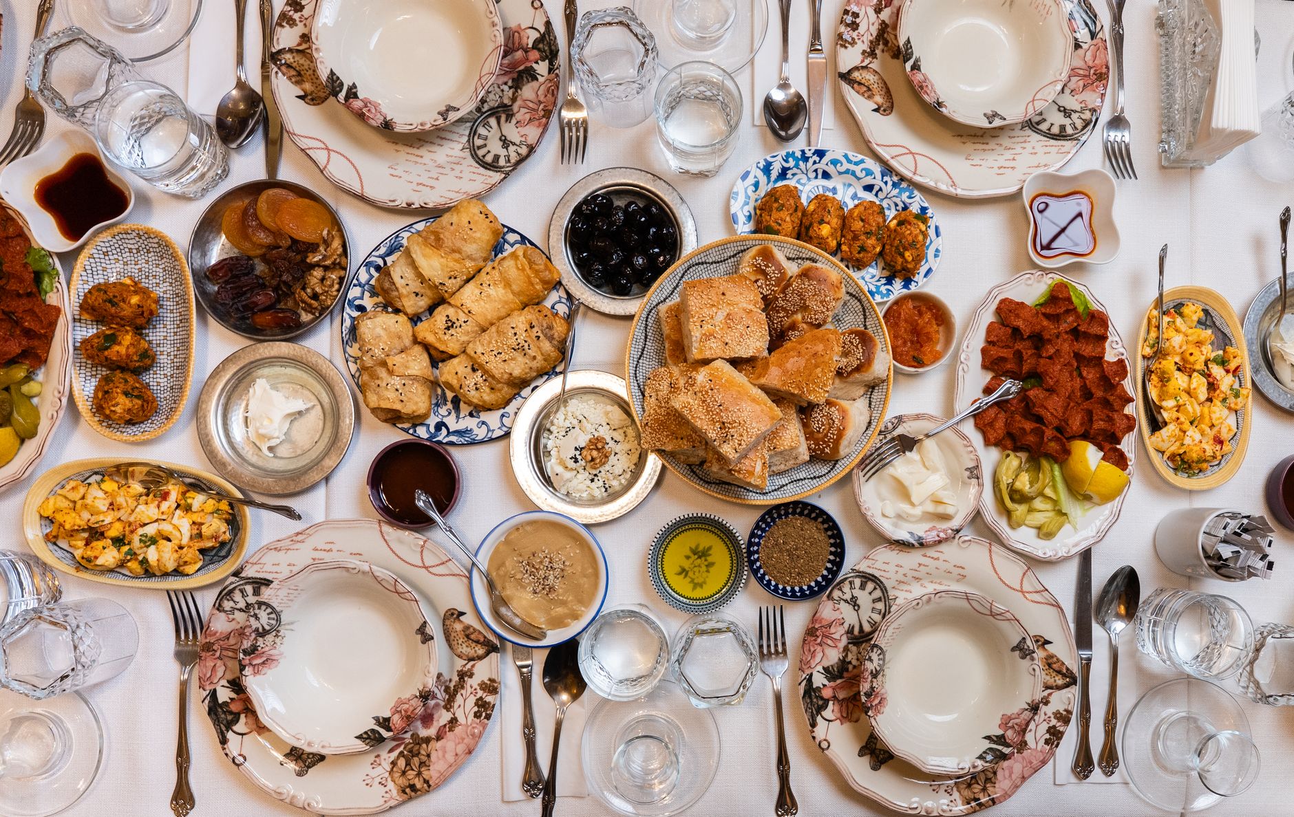 A beautifully arranged Turkish feast with gluten-free dishes including lentil soup, grilled vegetables, and olives.
