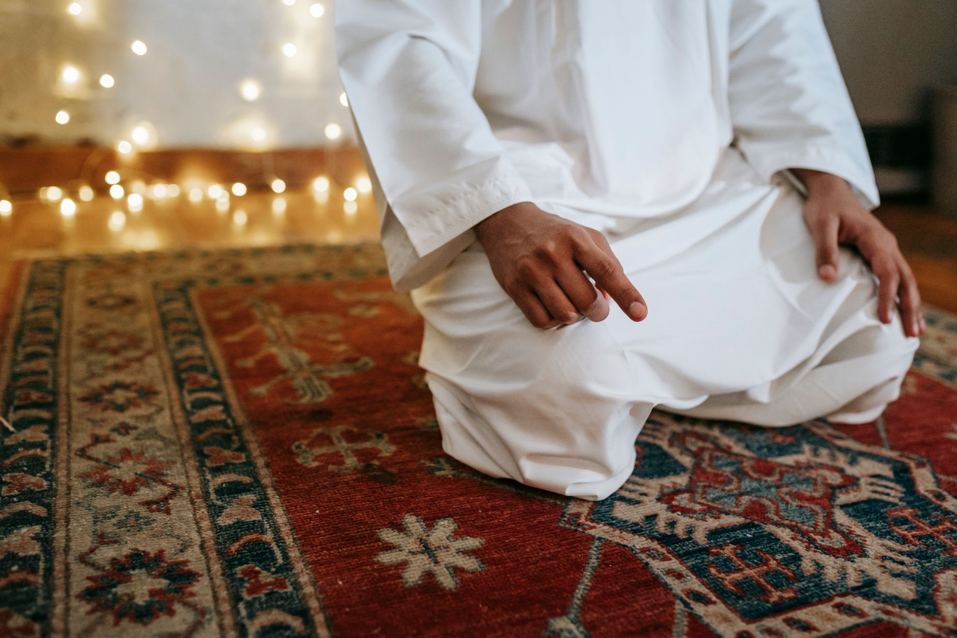 A person kneeling on a prayer mat in a serene hospital prayer room.