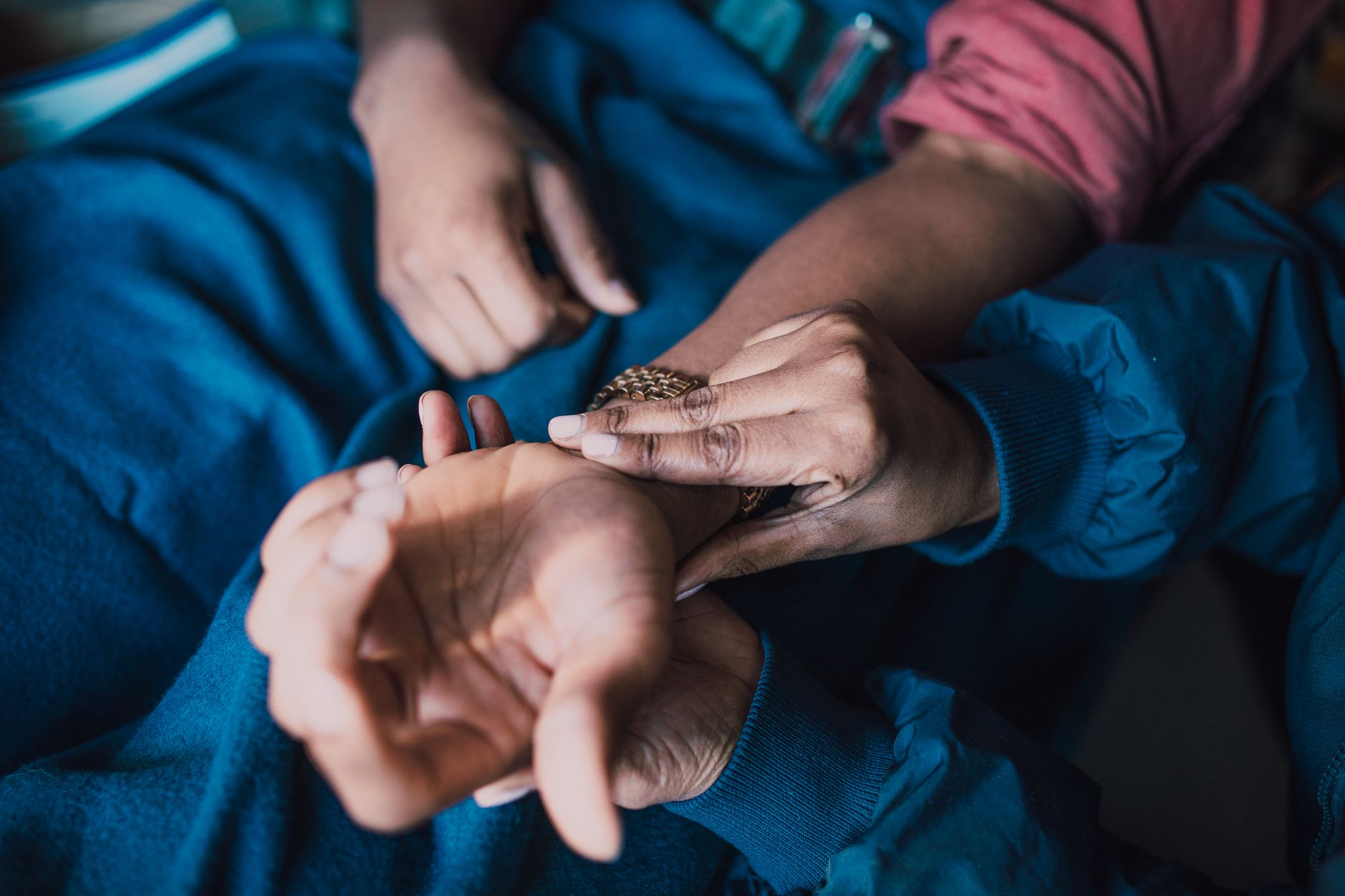 Doctor gently examining patient's wrist, emphasizing compassionate care during treatment discussion.