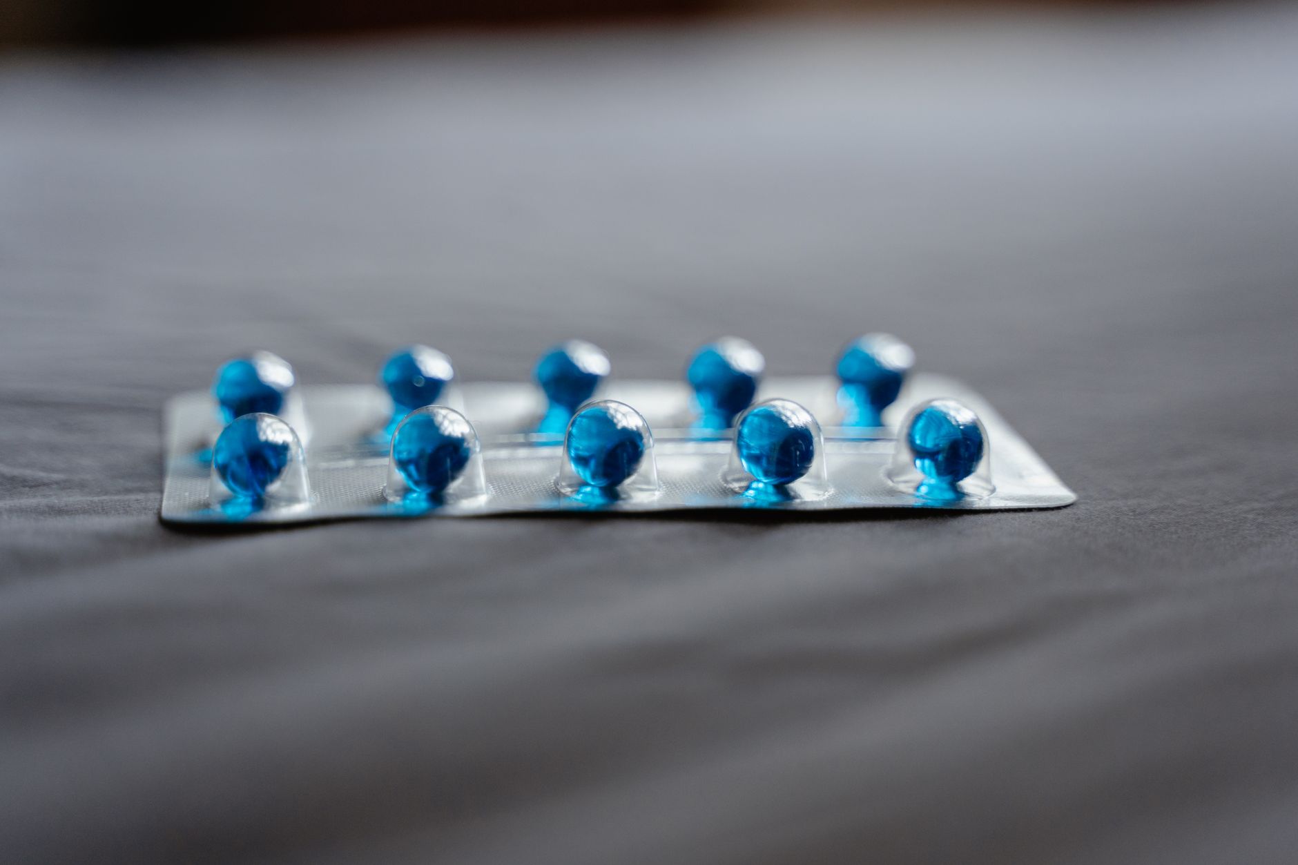 Close-up of blue capsules on a blister pack, representing antiviral medication for hepatitis.