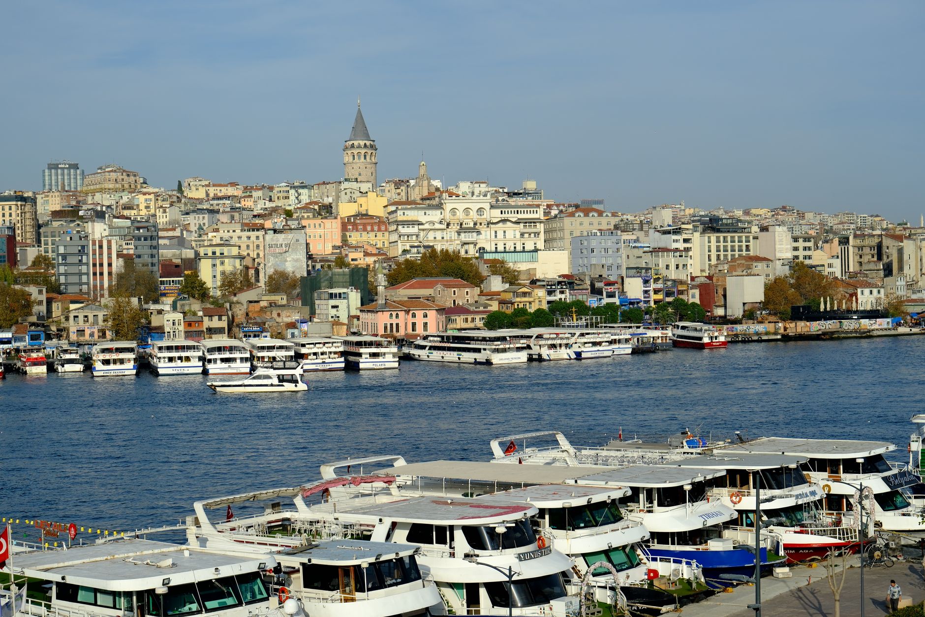 A scenic view of Istanbul's skyline featuring the Bosphorus, boats, and the iconic Galata Tower.