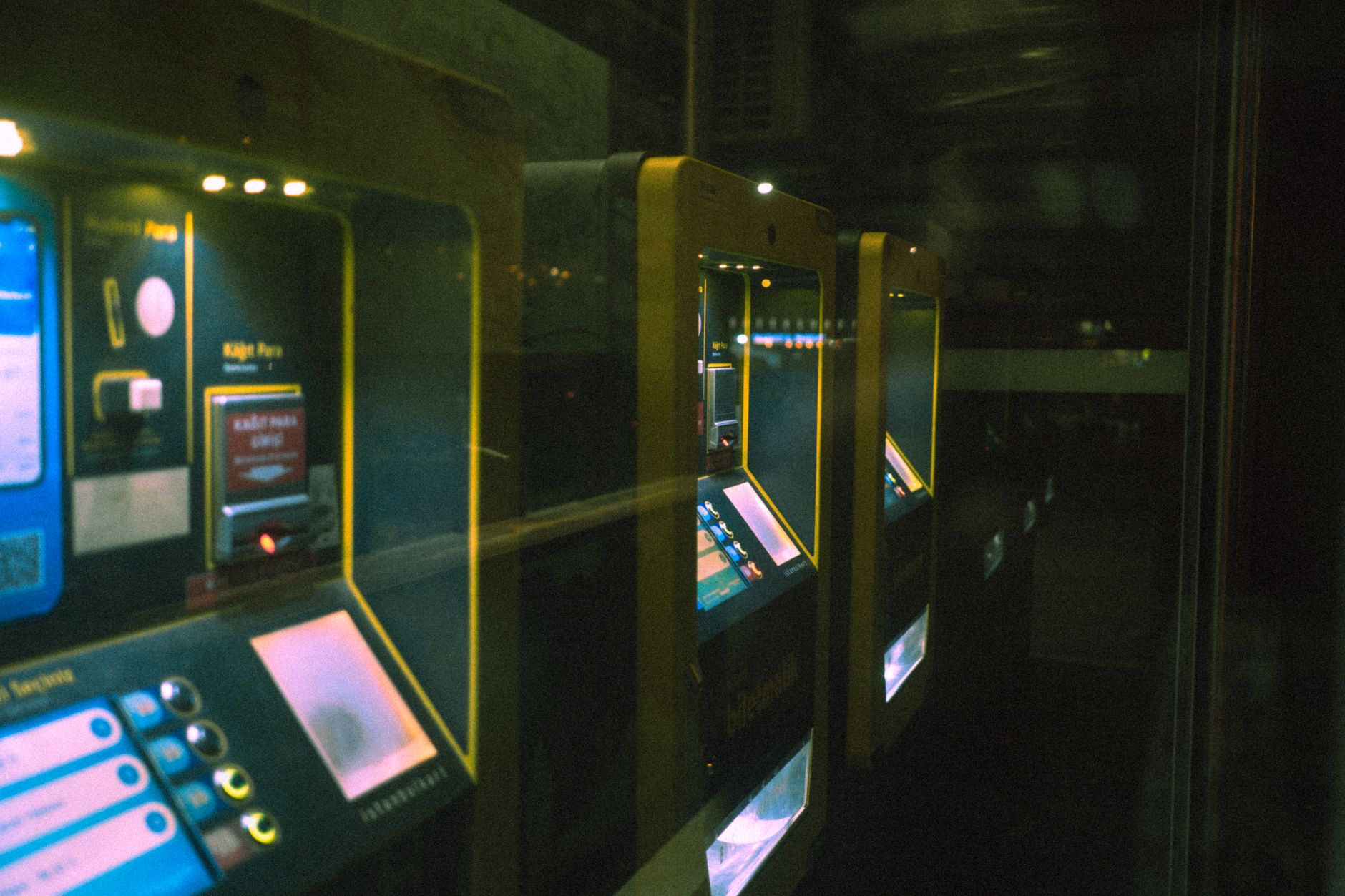 Dimly lit rail ticket machines, ideal for booking affordable travel to medical appointments.