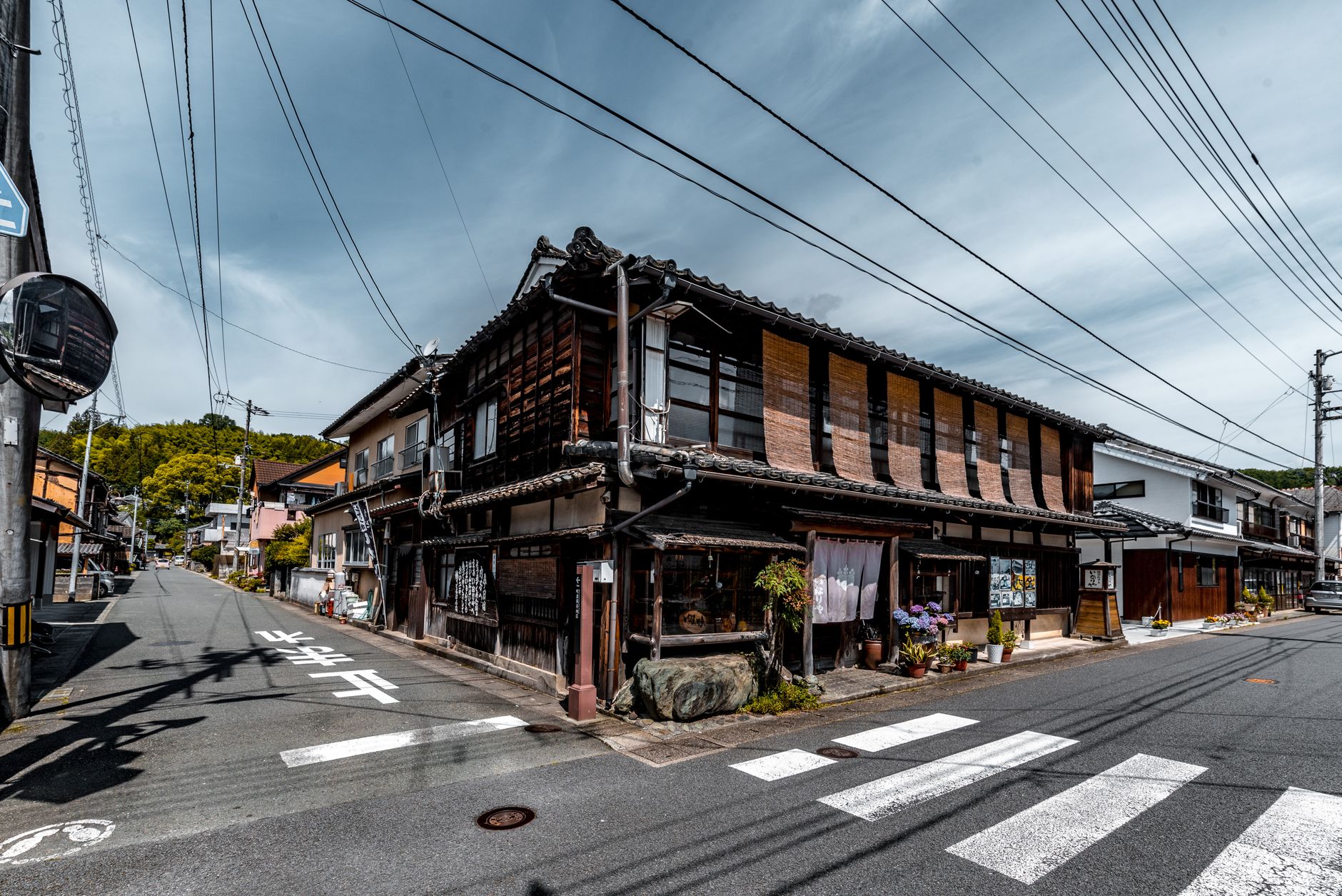 Peaceful village lane in Cide, featuring old wooden houses and colorful flowers.