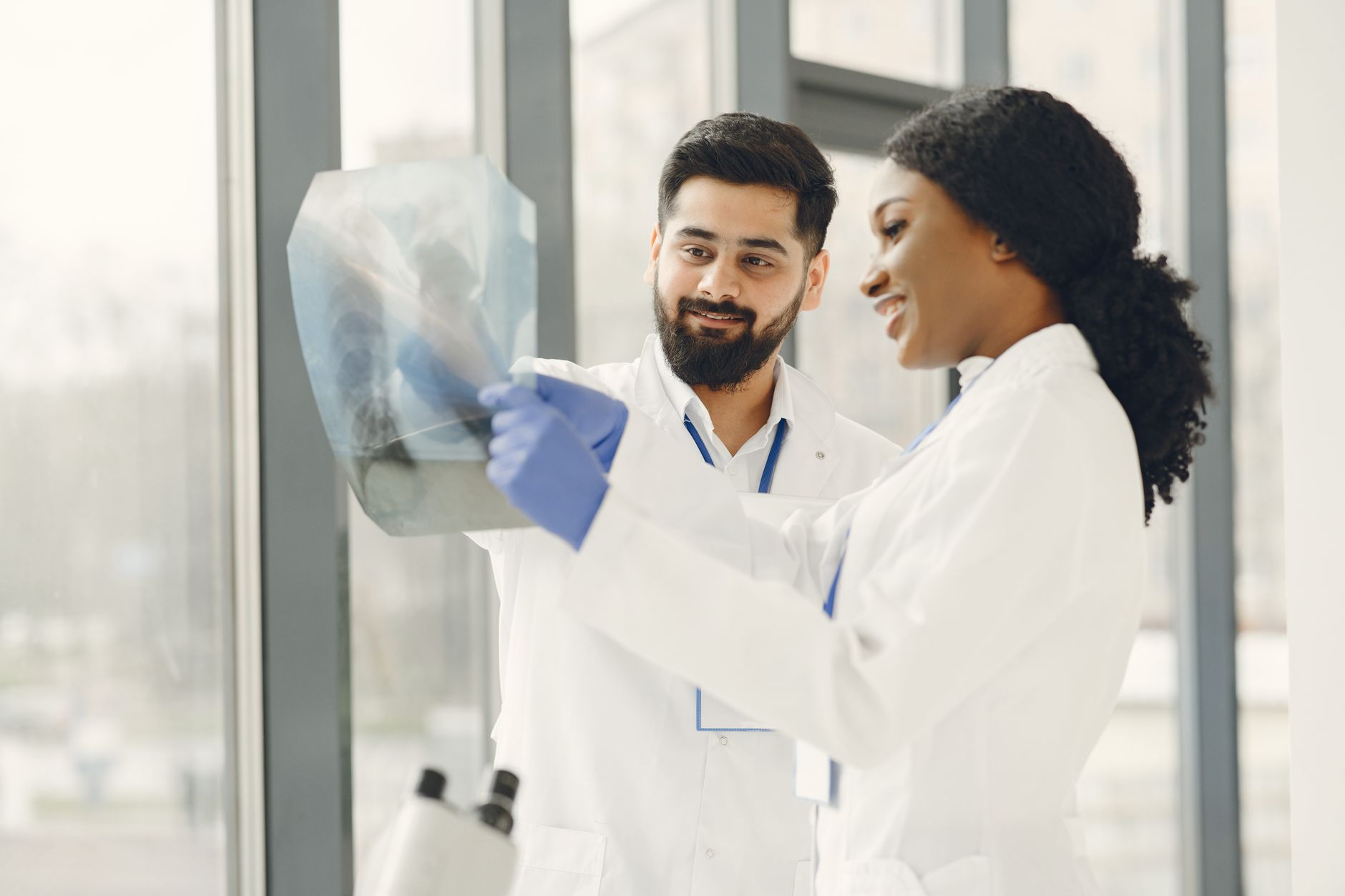 Two doctors examining an X-ray together, discussing findings in a modern medical environment.