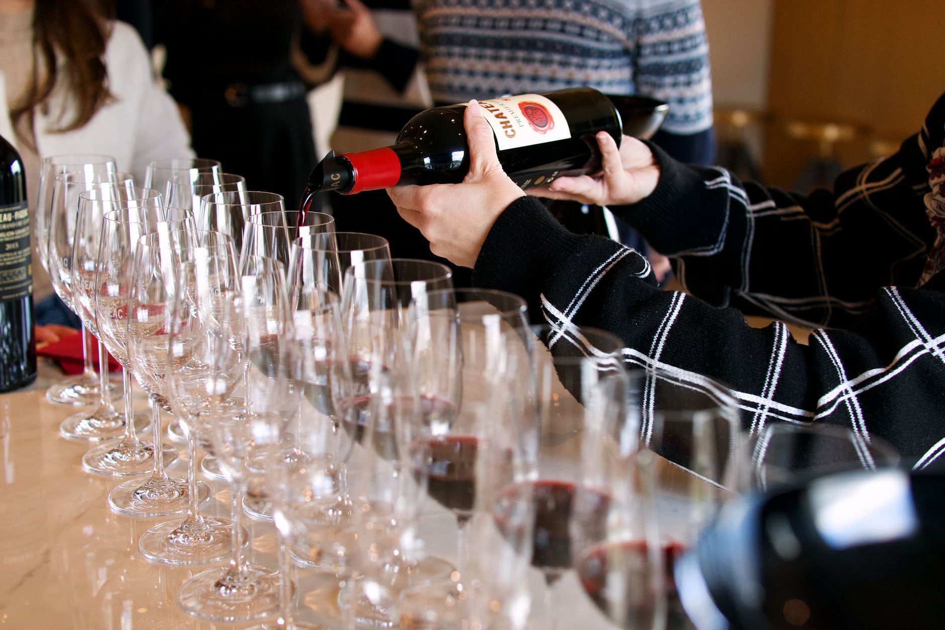 Wine being poured into glasses during a family winery tasting with local cheese.