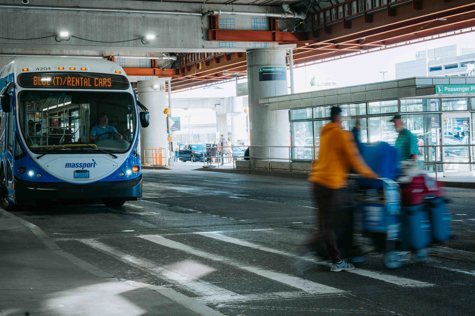 A bus for rental cars at Istanbul Airport, with passengers crossing the street.
