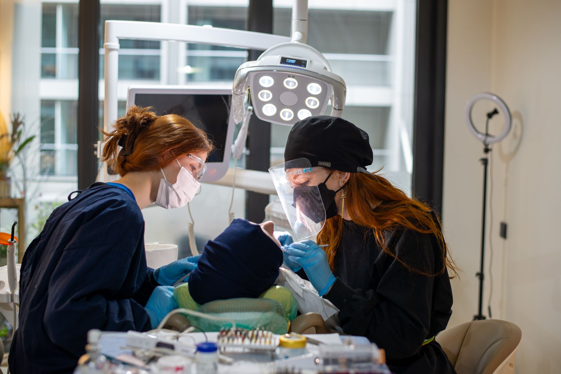 Two dental professionals assess a patient in a modern Turkish clinic.