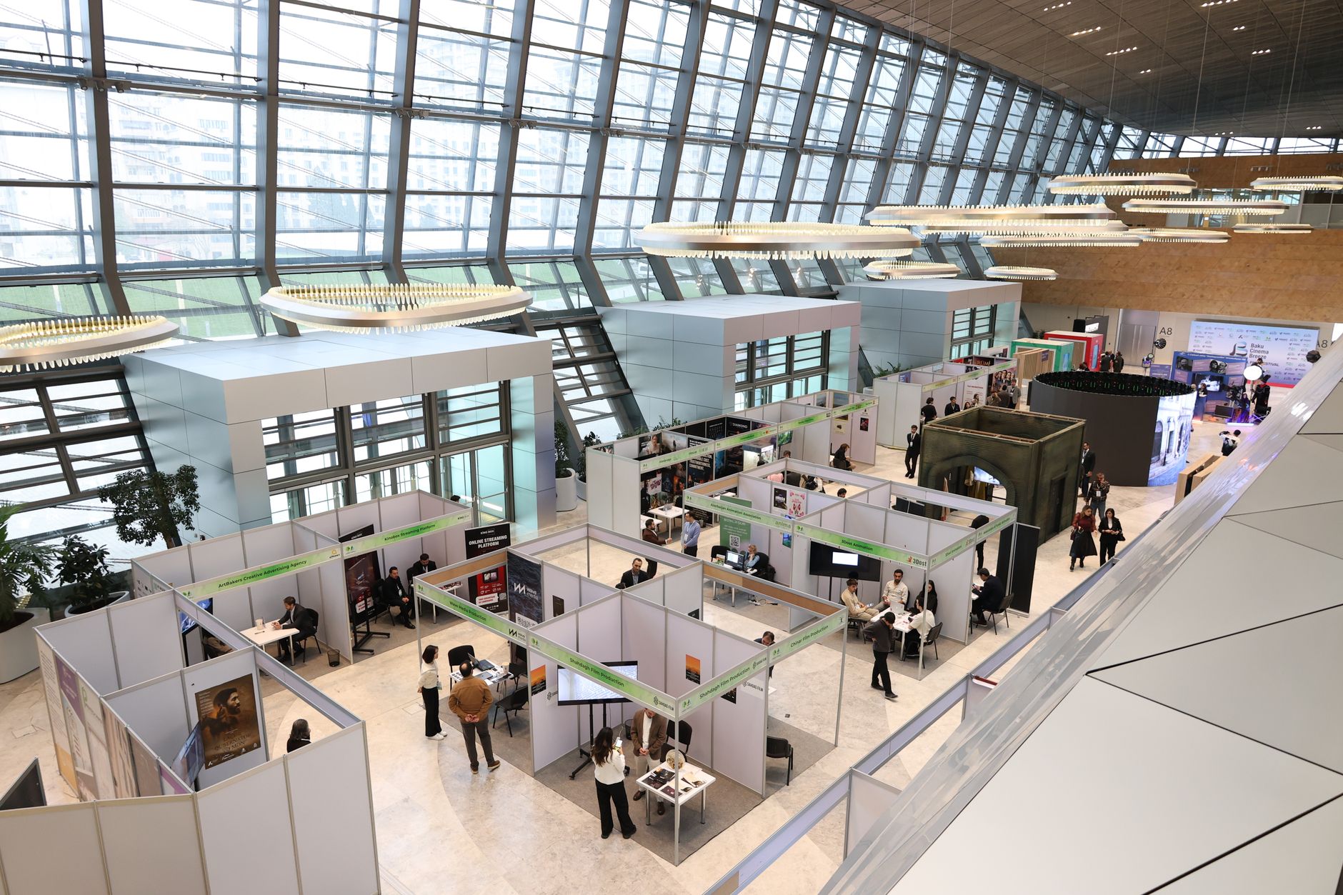 Aerial view of a vibrant health-tech expo with booths and attendees.