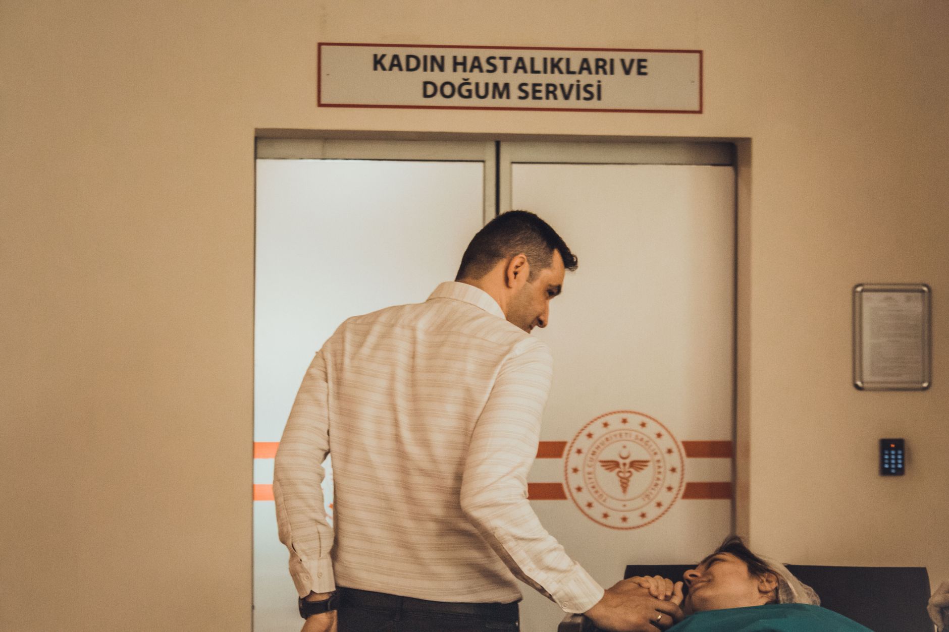 A man comforting a woman in labor at a Turkish maternity ward.