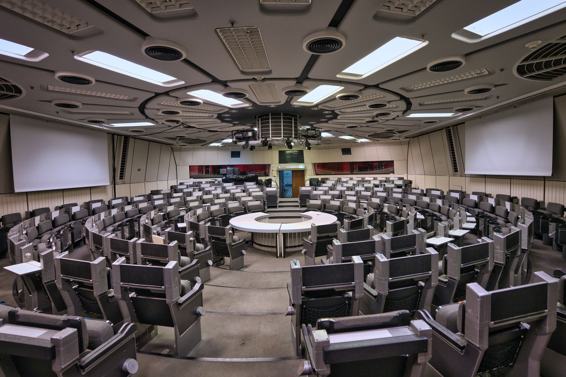 Interior view of a modern conference hall with circular seating for medical delegates.