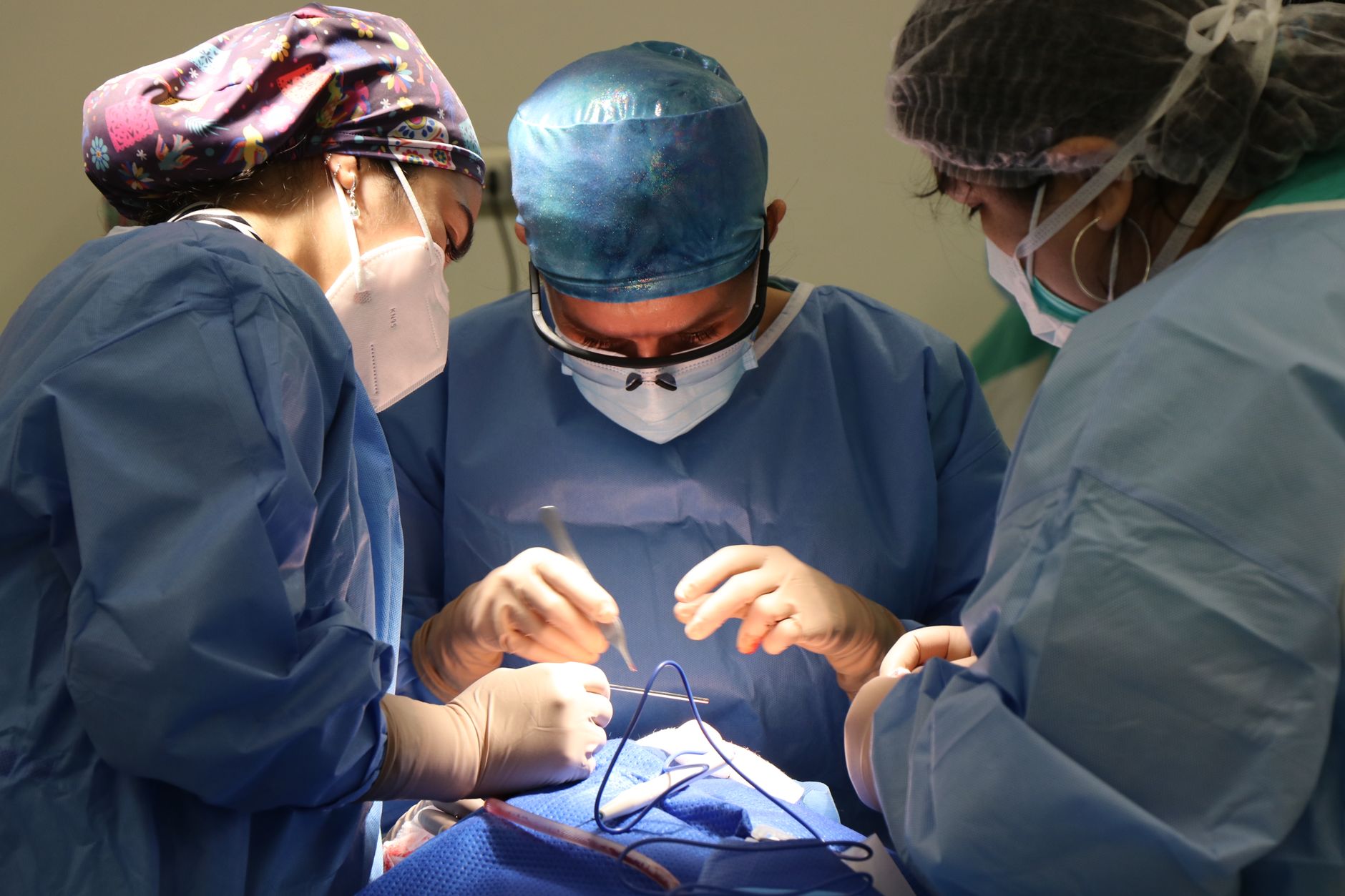 A group of surgeons performing a delicate operation in an operating room.