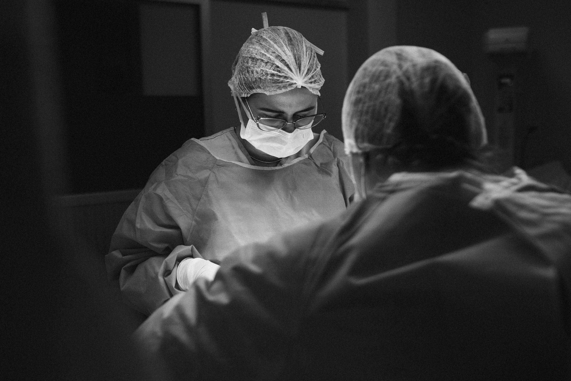 A focused surgeon and assistant work diligently in an operating room.