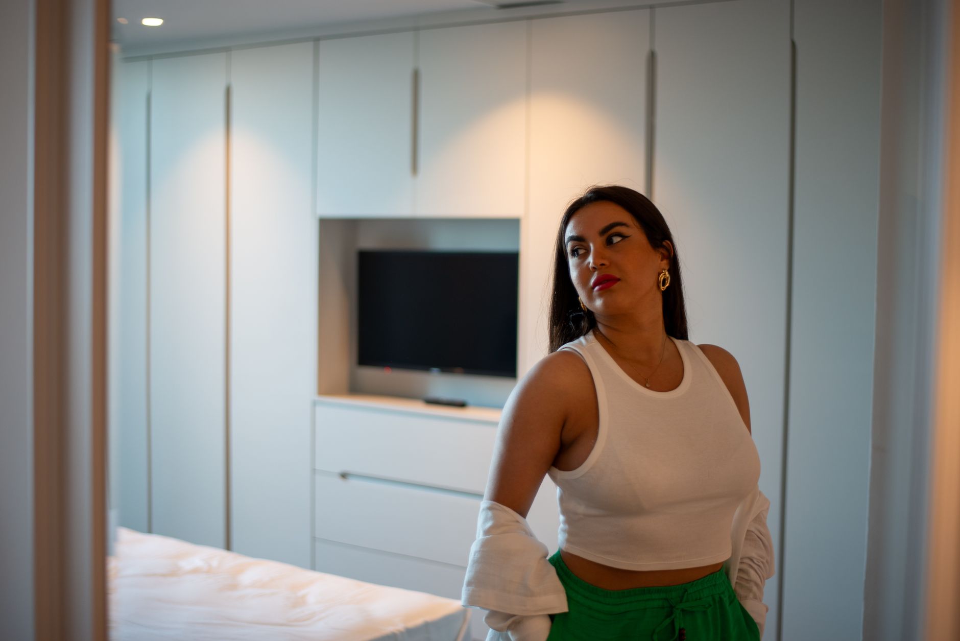 A woman poses in a modern hotel suite in Istanbul, featuring minimalistic decor.