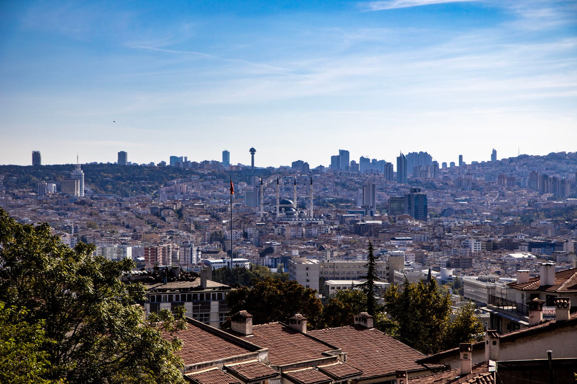 A panoramic view of Ankara's skyline featuring Atakule Tower amid urban buildings.