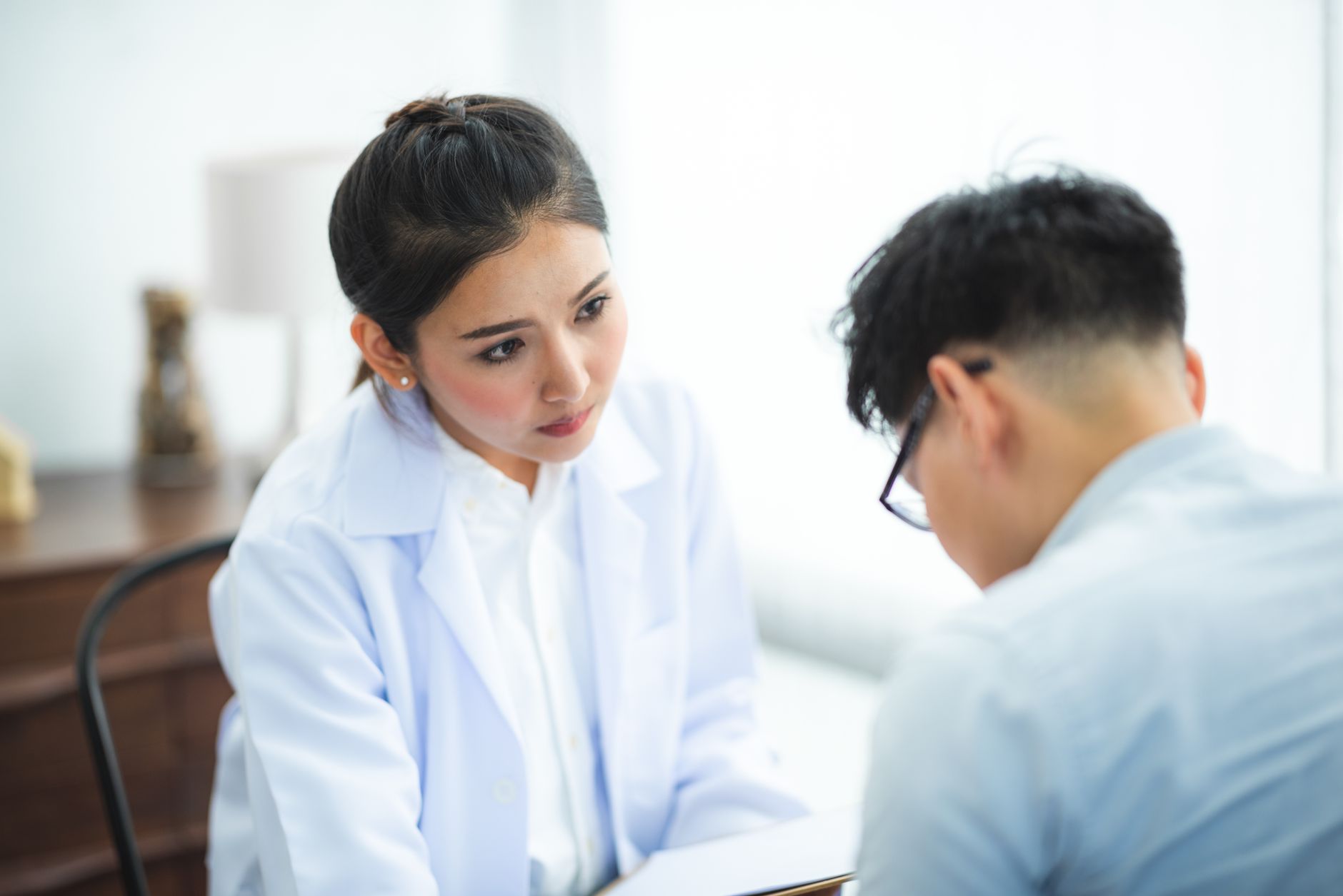 A doctor discusses treatment options with a patient in a calm, supportive environment.