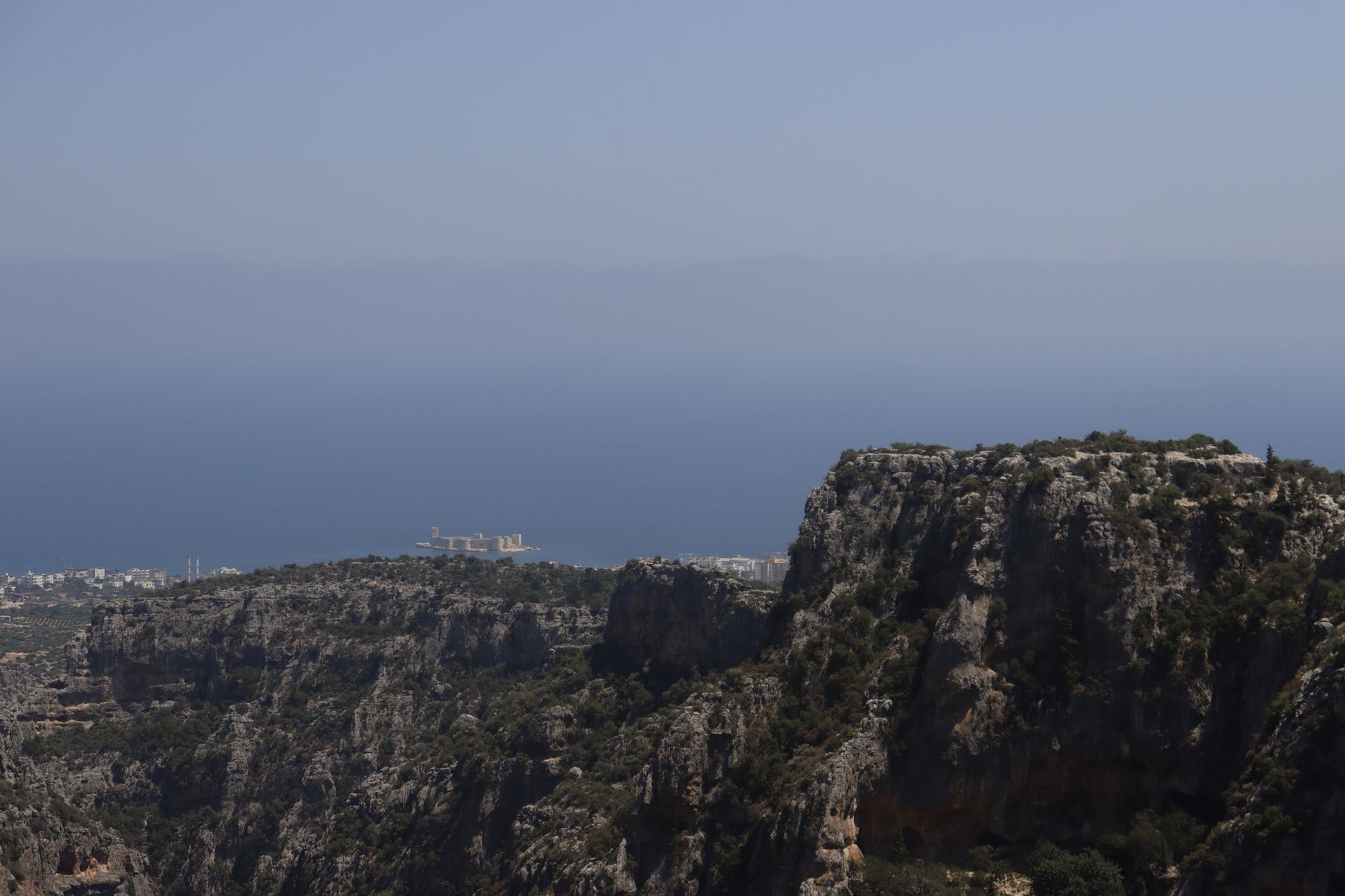 Panoramic view of Mersin coast featuring a sea castle and rocky cliffs.