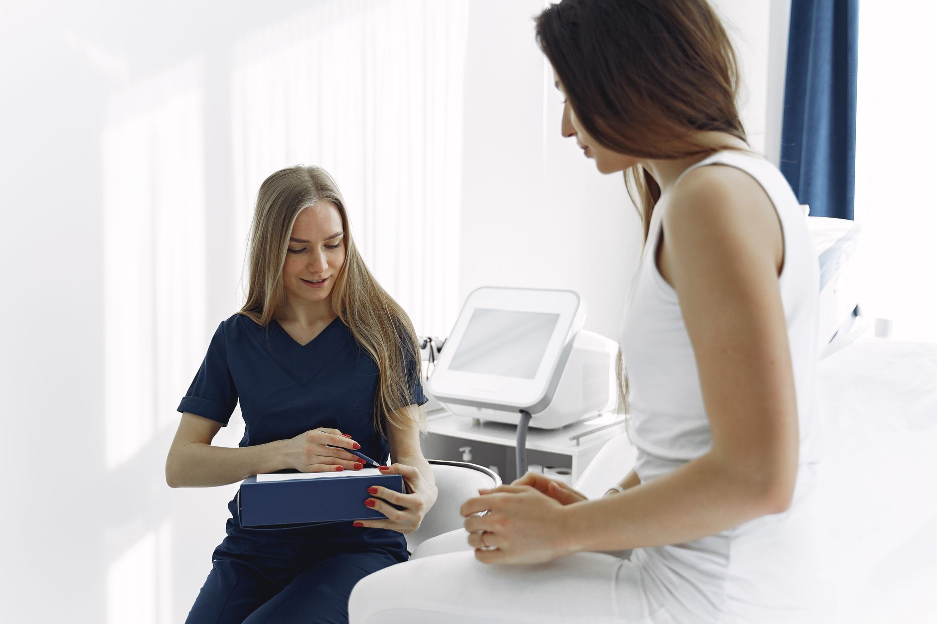 Healthcare professional discussing monitoring scan with patient at fertility clinic.