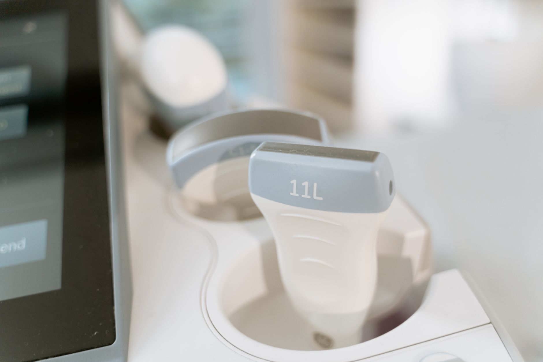 Close-up of ultrasound scan device with indicator '11L' used in ovarian stimulation monitoring.