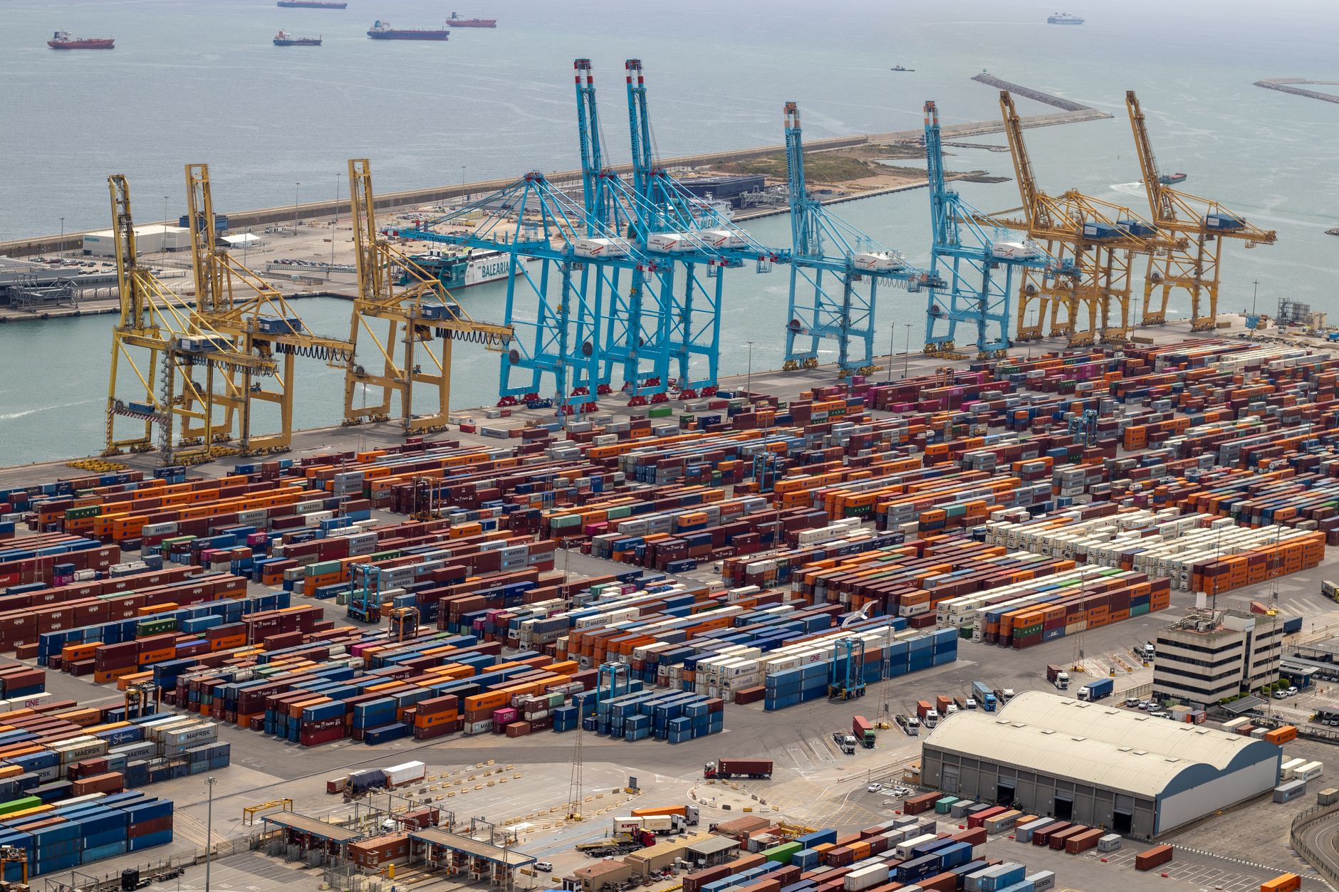Aerial view of Mersin Harbour showcasing cargo containers, cranes, and nearby ships.