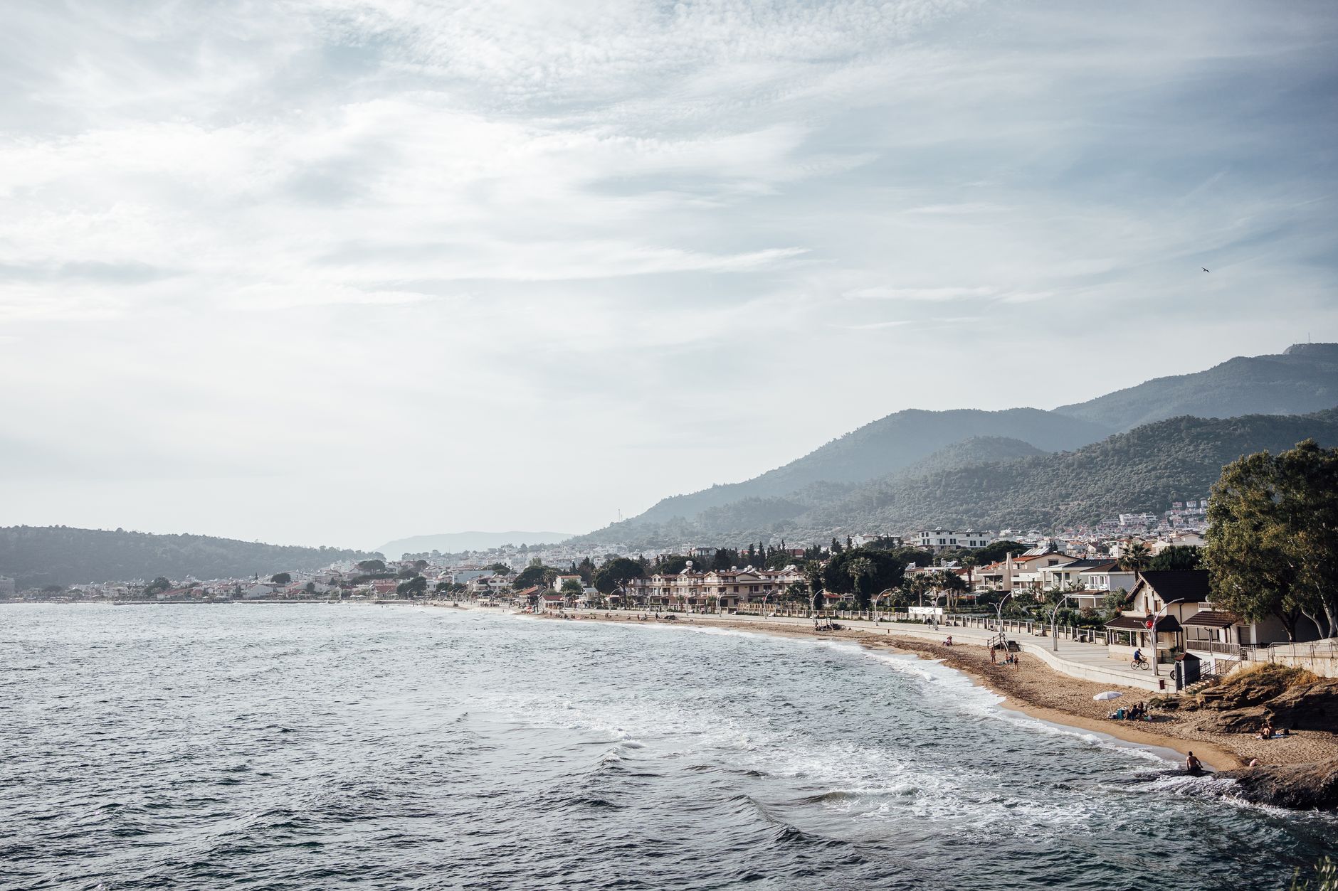 A picturesque coastal view of a traditional village on the Karaburun Peninsula with taverns by the beach.