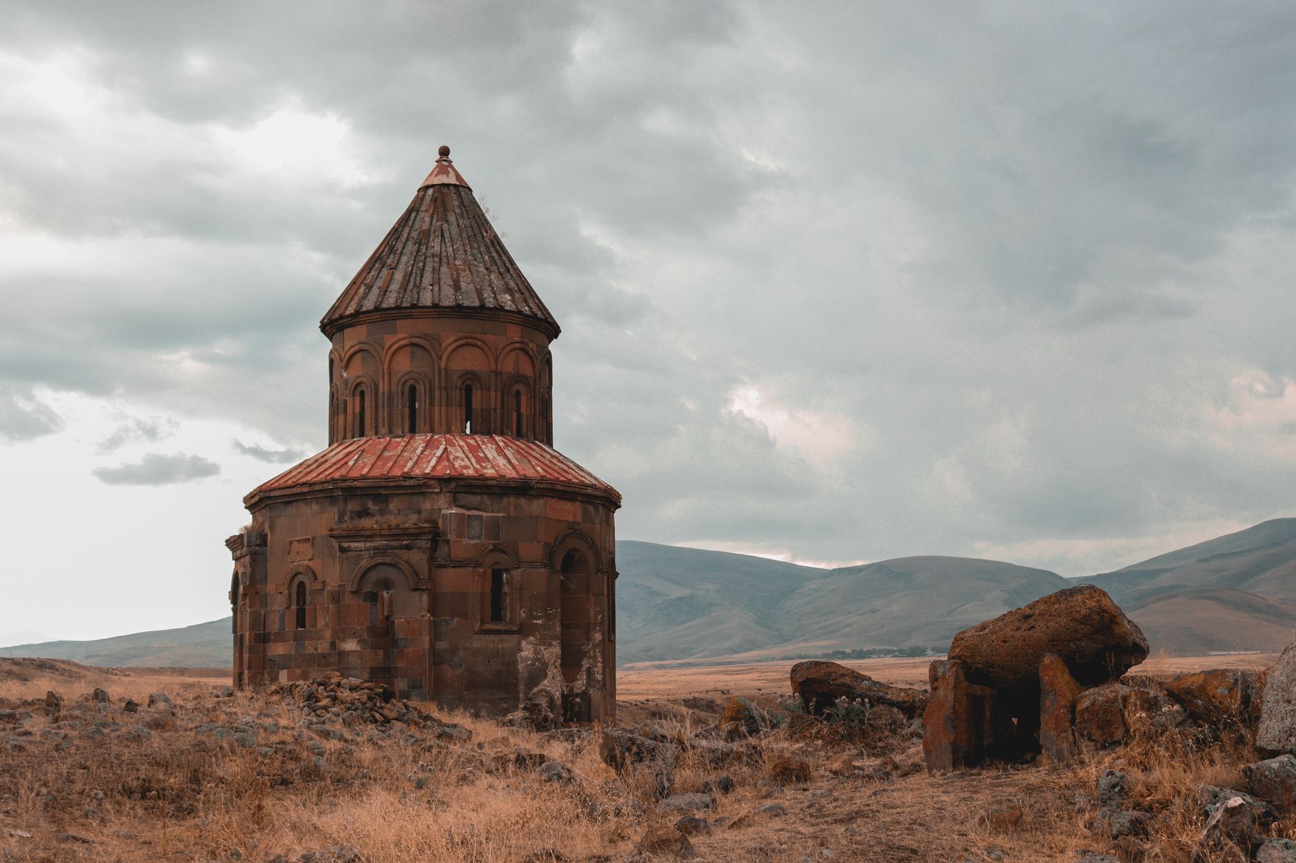 Крупный план собора Ани, демонстрирующий его архитектурные детали на фоне драматичного неба.