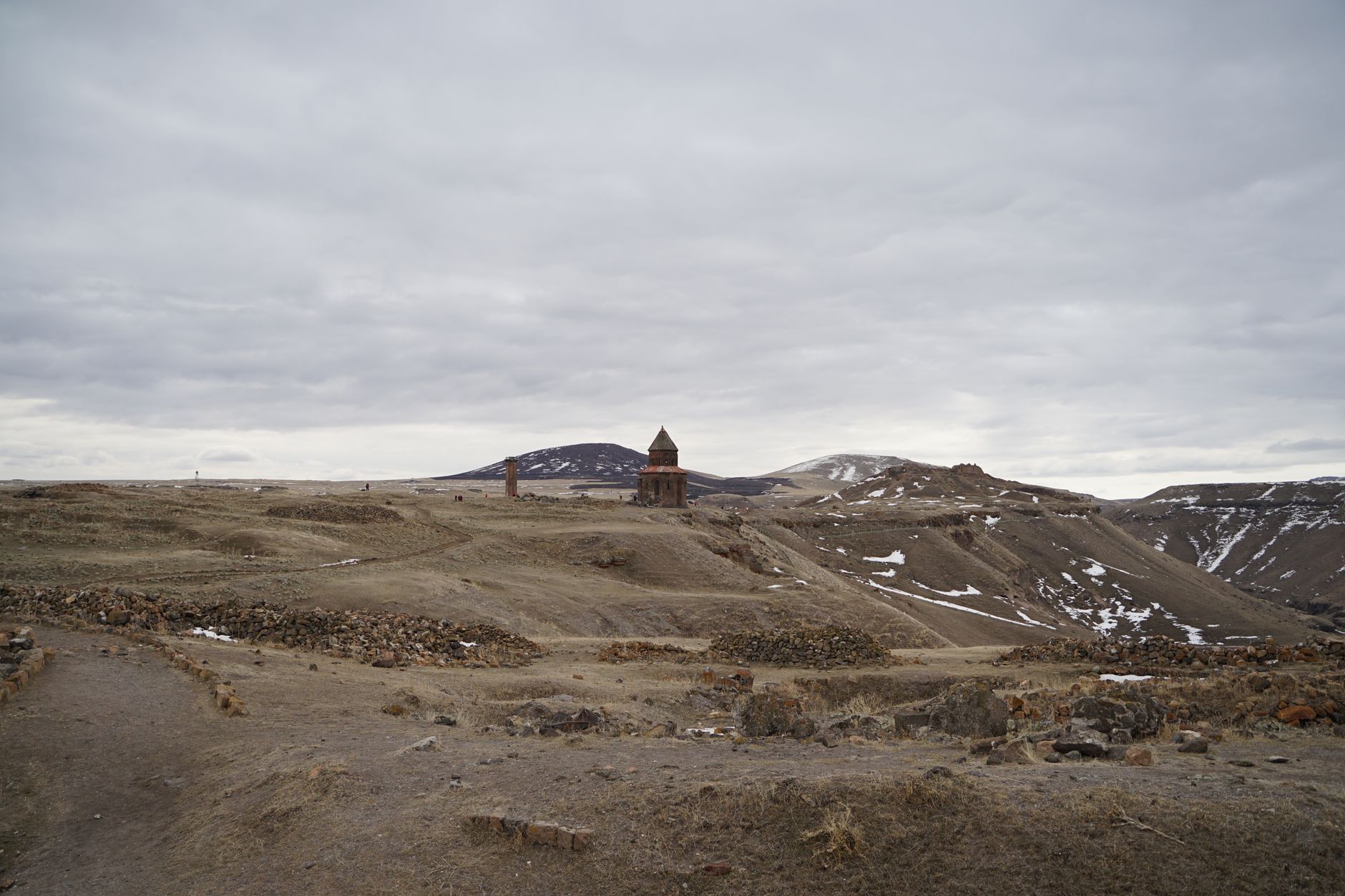 Landscape of the ancient ruins of Ani in Armenia, featuring churches and arches on a vast plain.