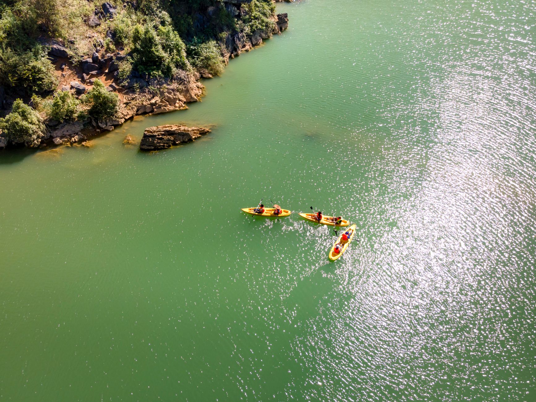 Aerial view of kayakers paddling in clear water near rocks in Kekova.