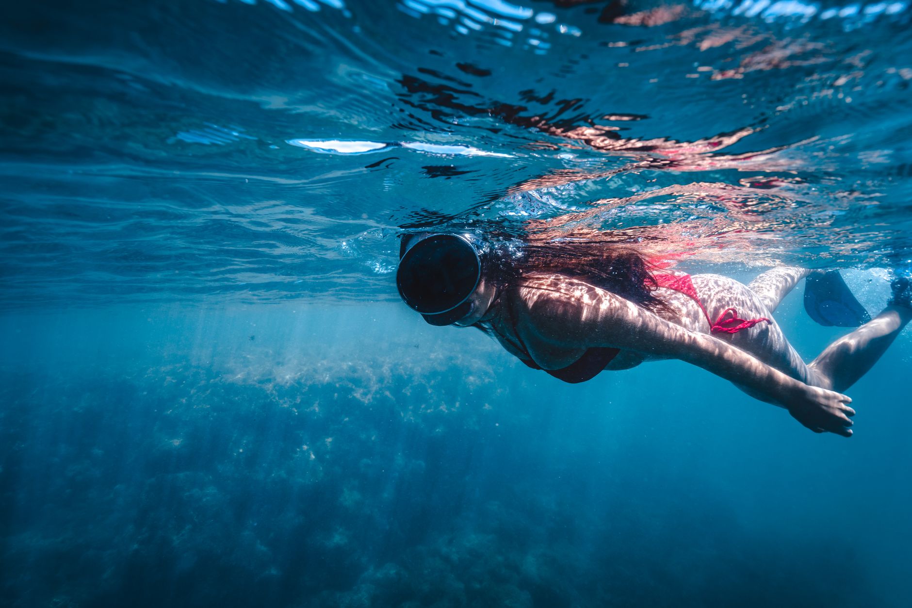 A snorkeler swims in clear waters of Kekova, with underwater ruins visible below.