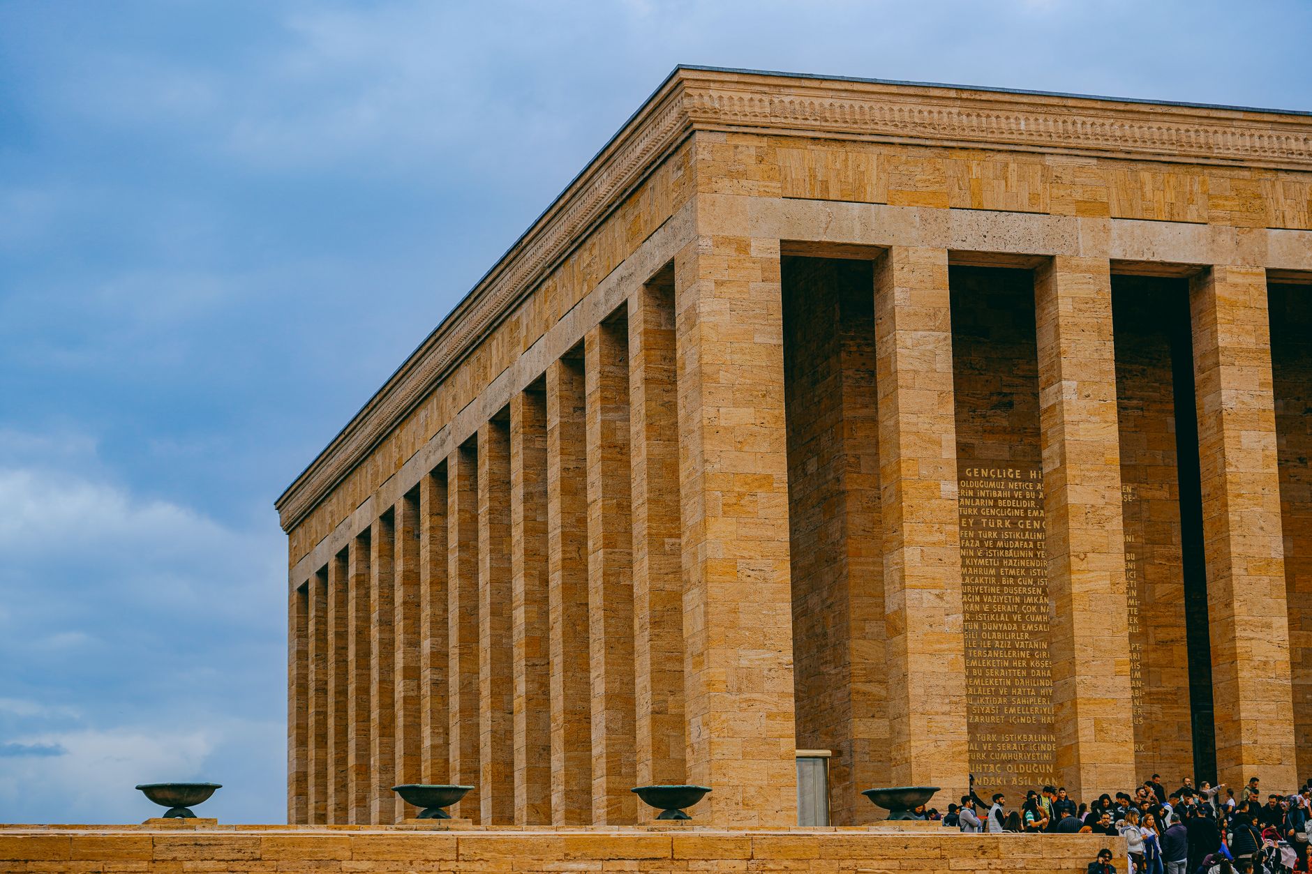 Anıtkabir, the mausoleum of Mustafa Kemal Atatürk, surrounded by visitors under a cloudy sky.