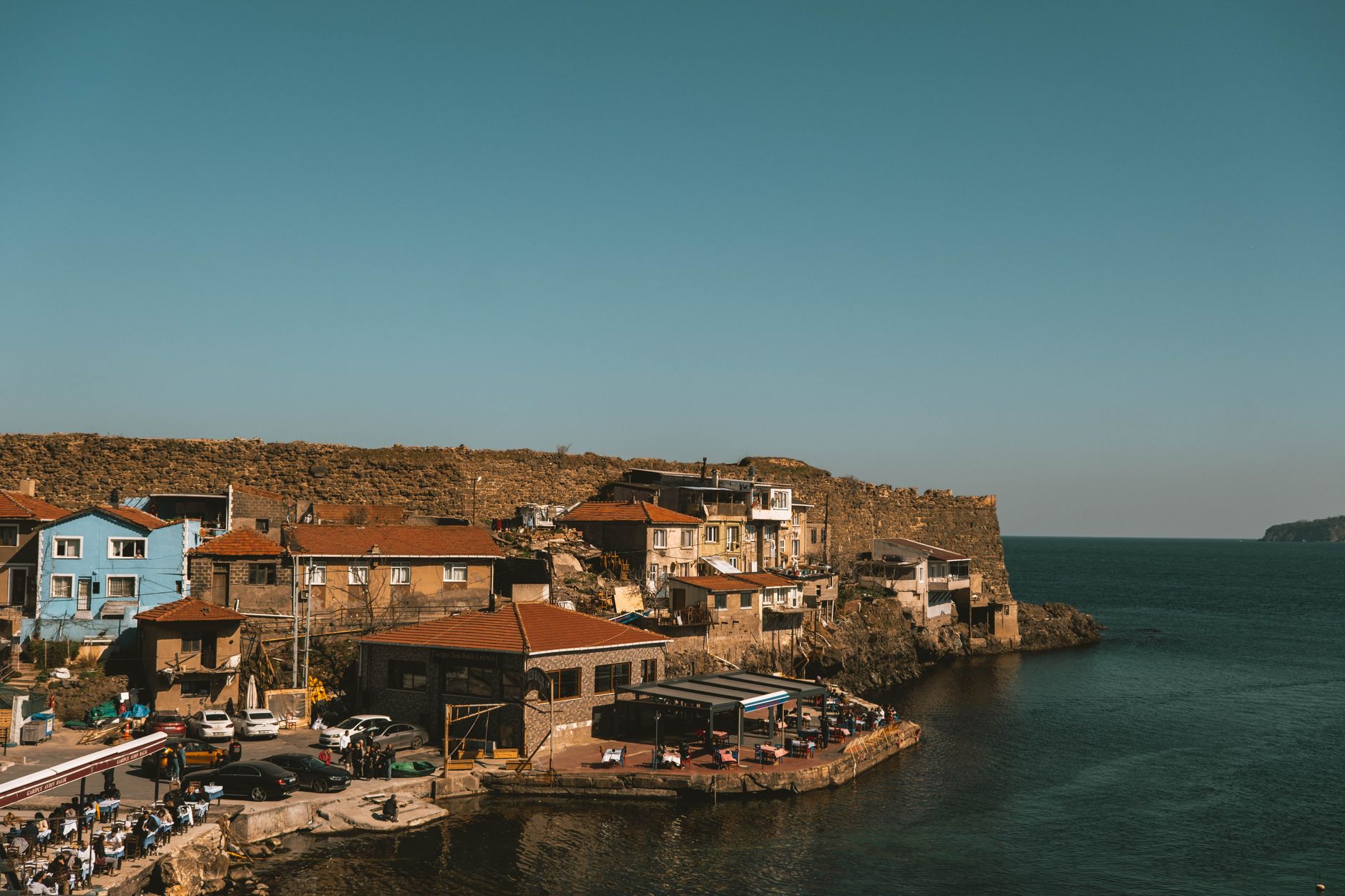 A scenic view of Kıyıköy featuring colorful traditional houses by the water.