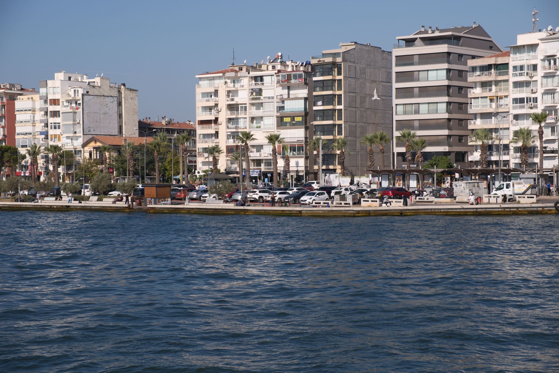 Overview of Mersin city showcasing a walkable seafront, buildings, and cars along the waterfront.