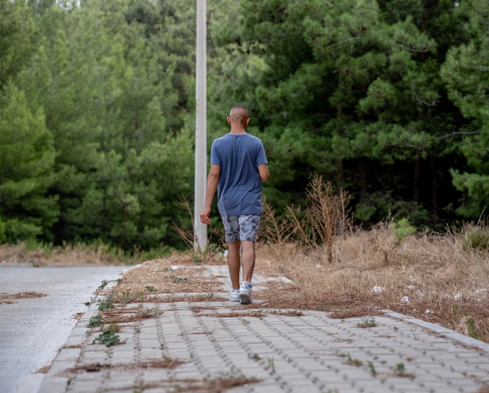 A patient walks along a path surrounded by greenery, enjoying fresh air as part of their recovery.