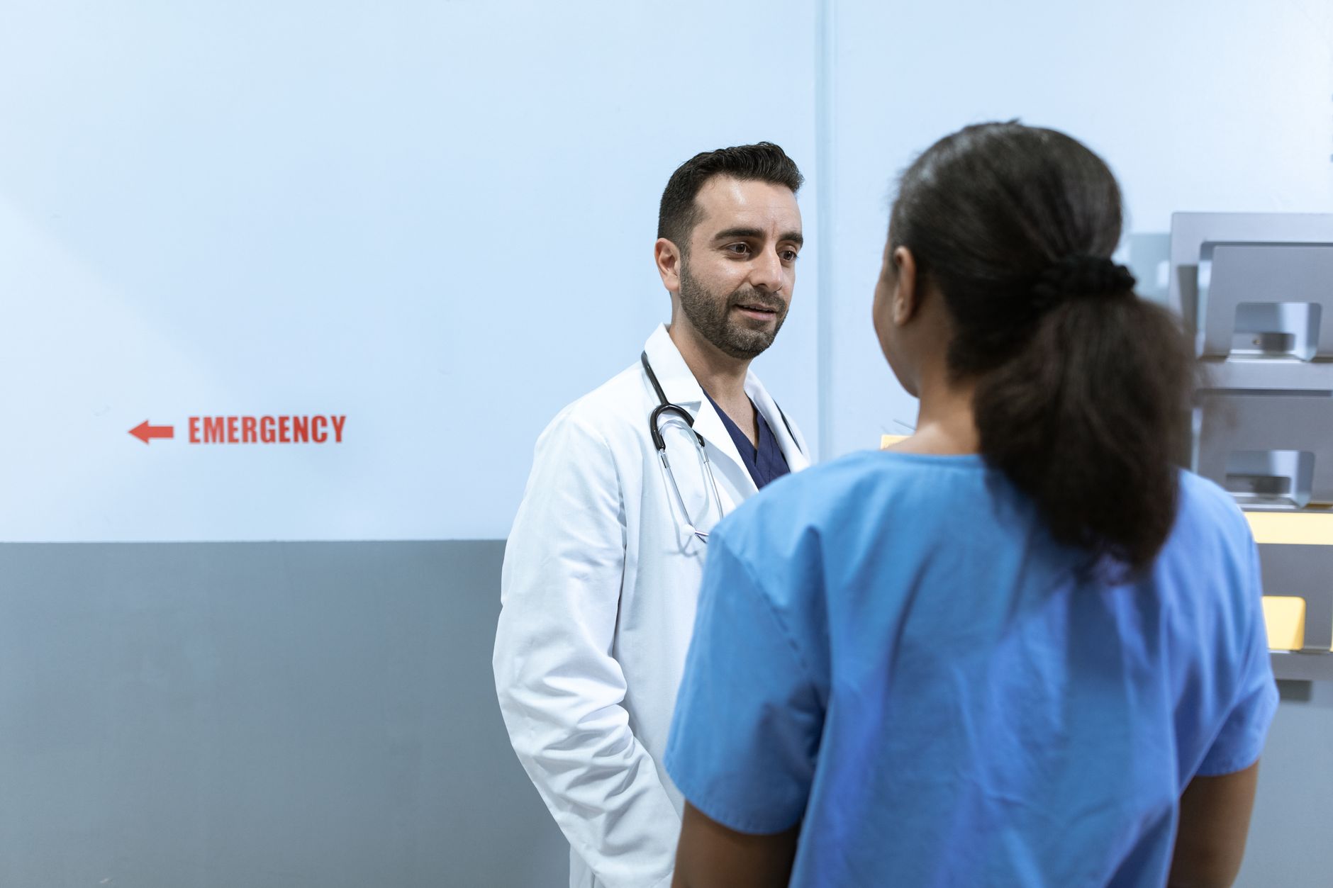 A physician explains a treatment plan to a patient in an emergency room.