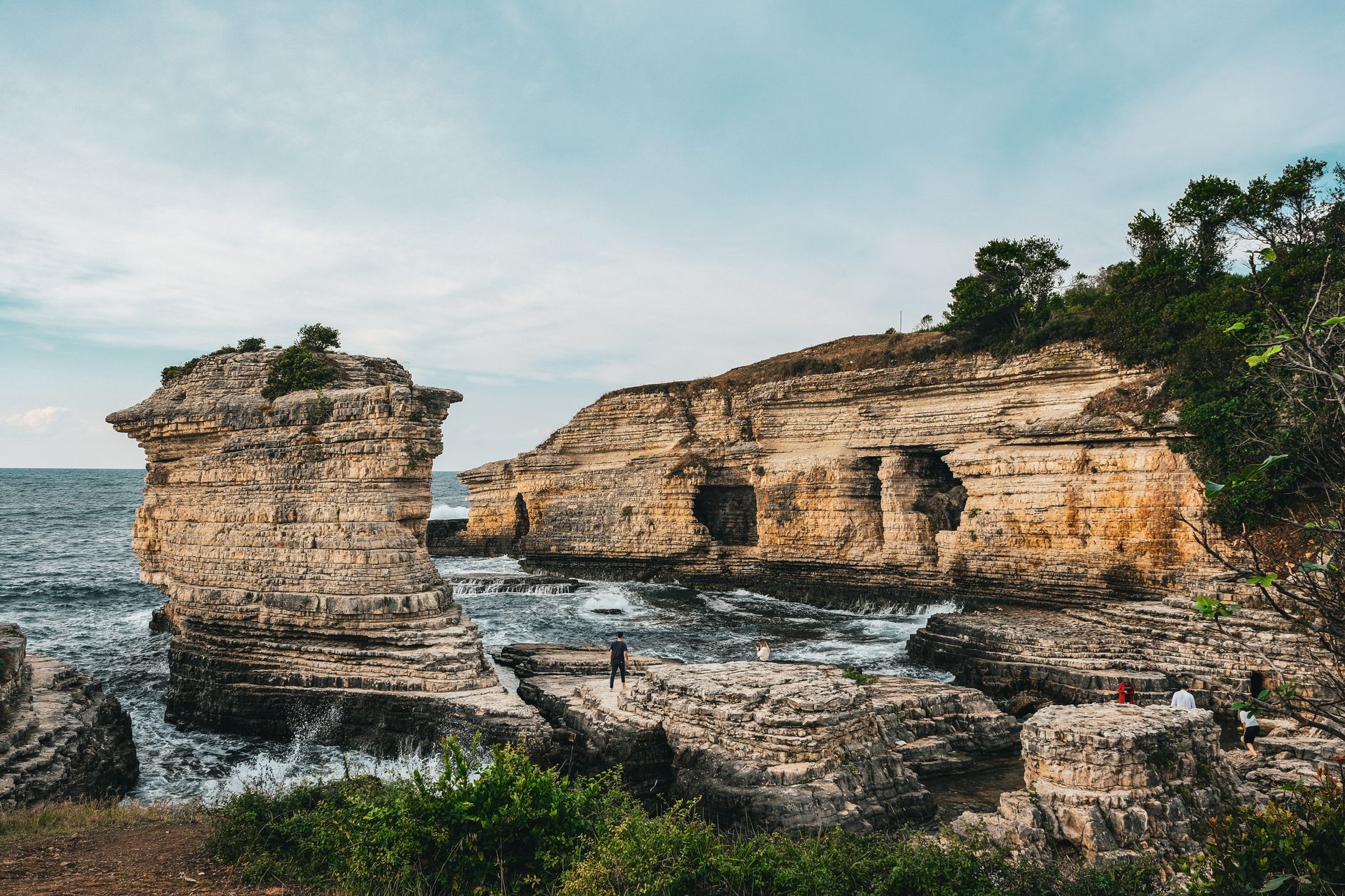 Stunning rock formations along the coast with gentle waves, perfect for family beach outings.