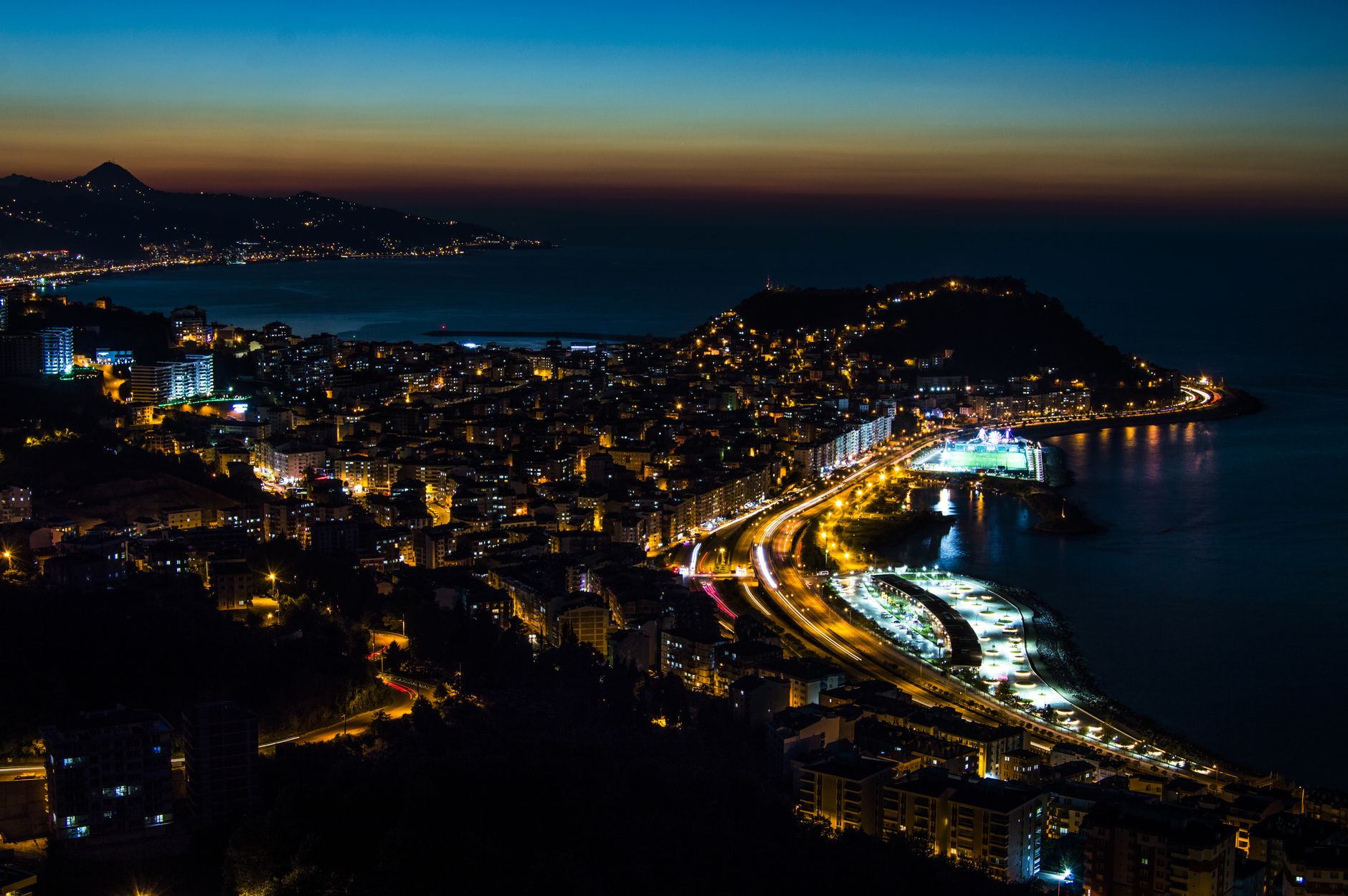 Giresun'un canlı bir limanı ve Karadeniz boyunca aydınlatılmış sahil şeridini içeren muhteşem gece panoraması.