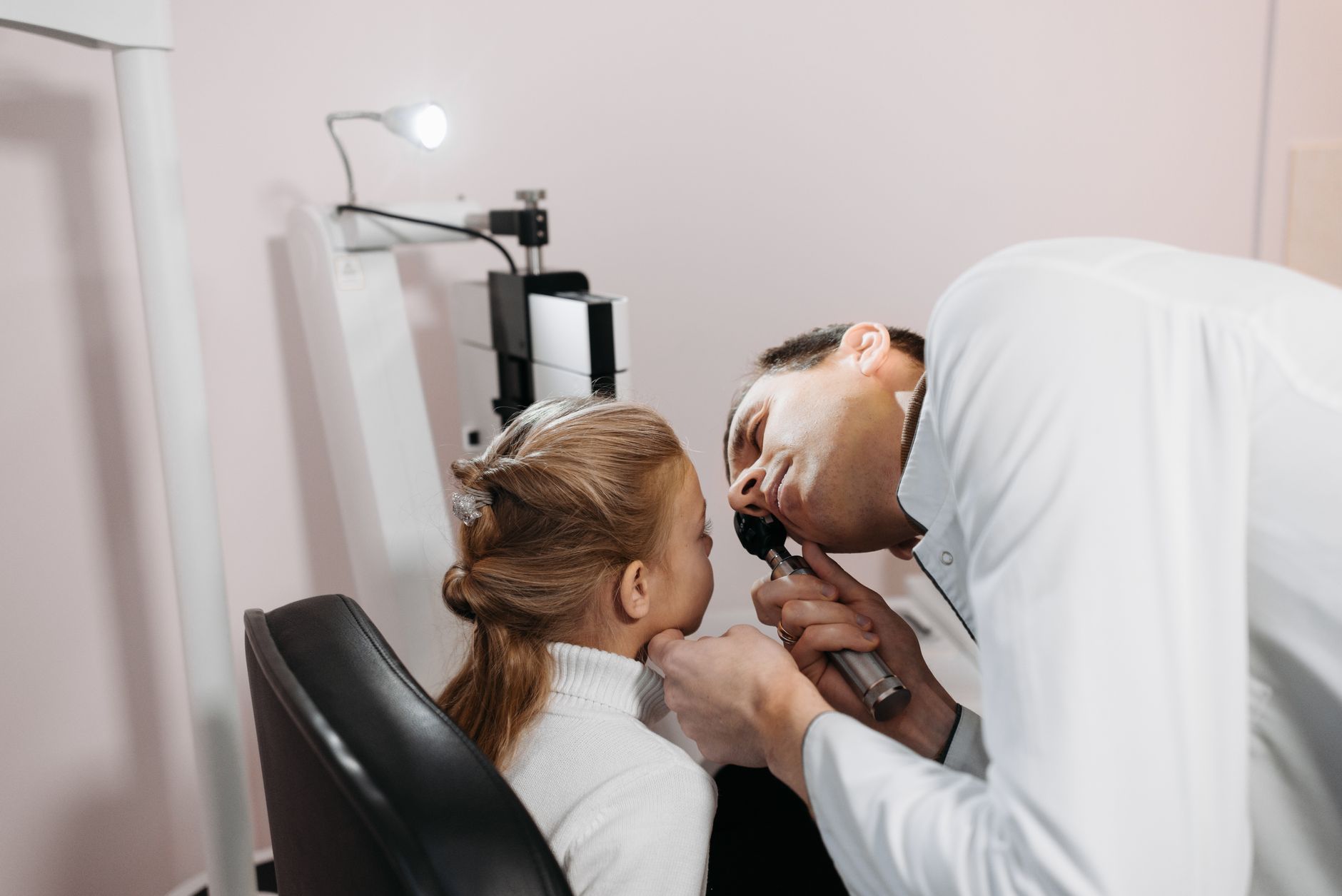 Doctor examining a child's ear in a Bursa clinic, showcasing attentive care.