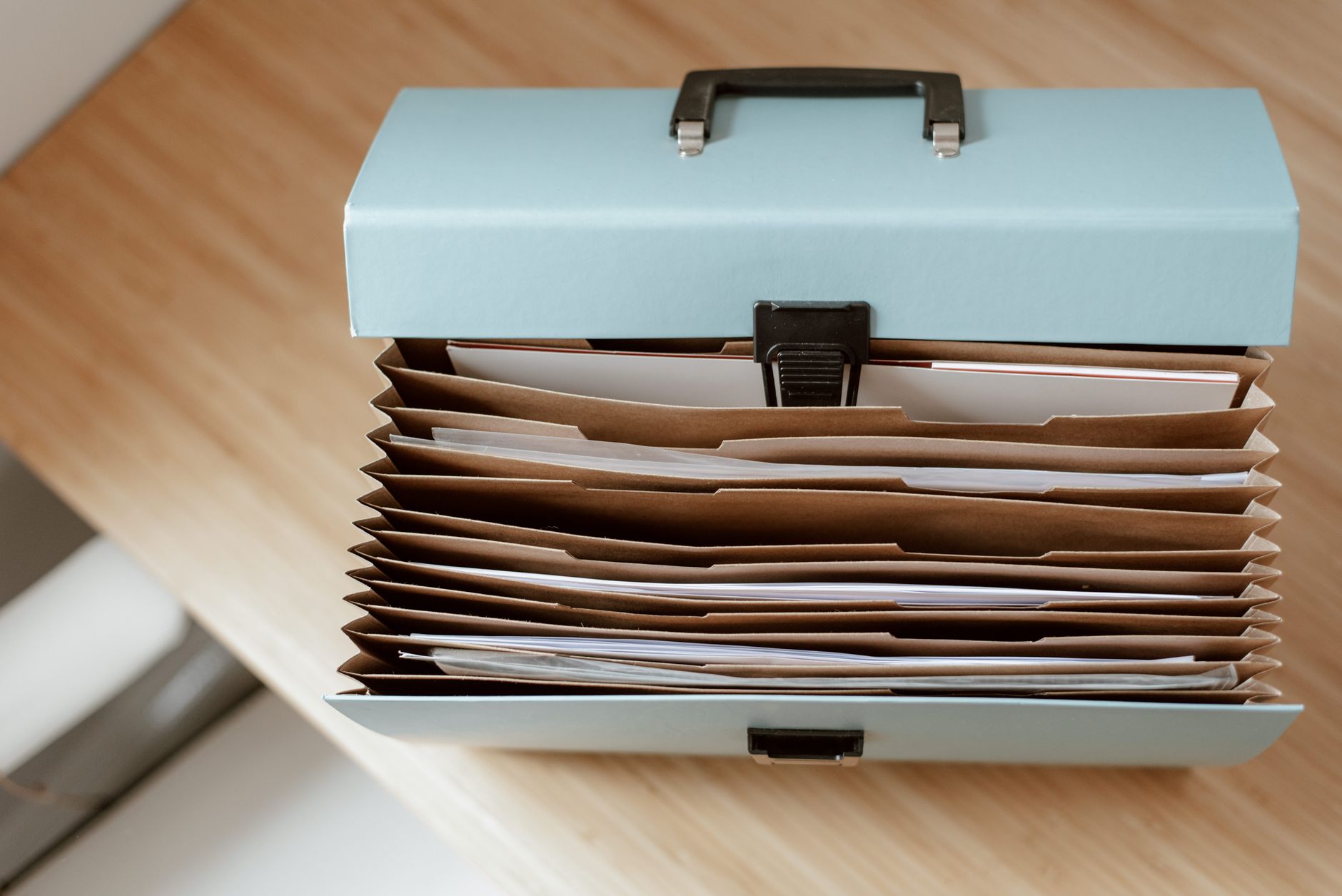Close-up of a blue folder filled with organized medical documents and a passport, emphasizing the importance of essential paperwork.