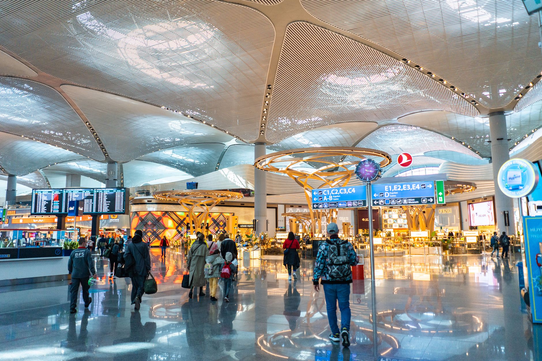 Interior view of Istanbul Airport with passengers walking towards boarding gates.