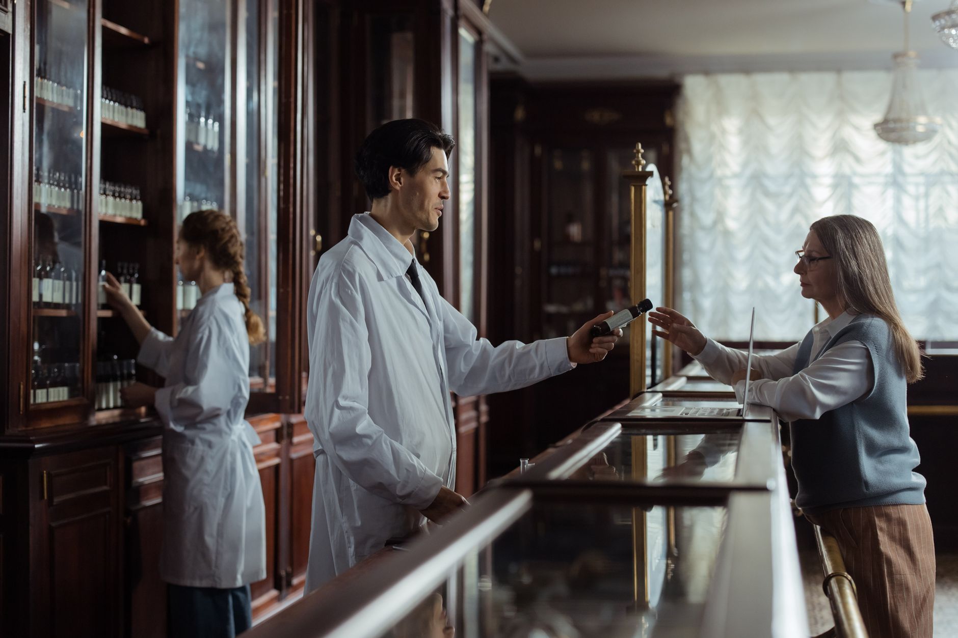 A pharmacist assists a patient with medication instructions in an elegant pharmacy.