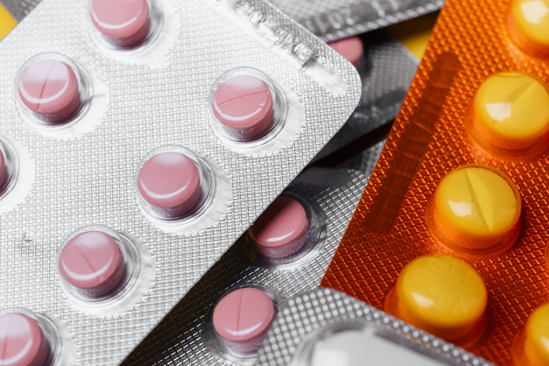 Close-up of various blister packs and medicine boxes showcasing colorful pills.