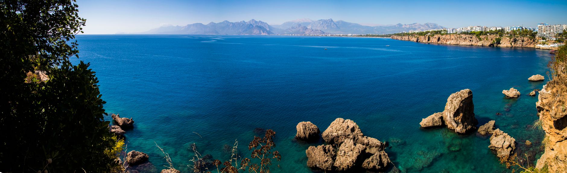 Panoramic view of Antalya's beautiful coastline, featuring turquoise waters and rocky cliffs.