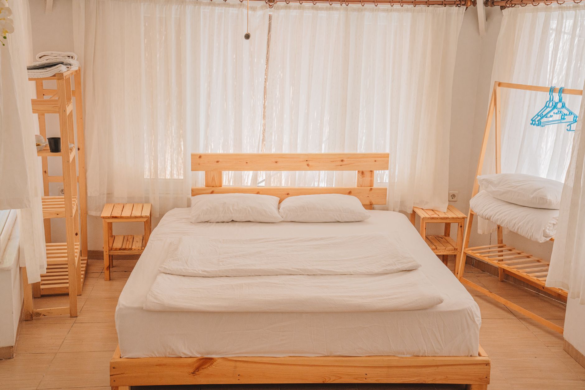 Bright private hospital room in Türkiye featuring a wooden bed, white linens, and ample natural light.