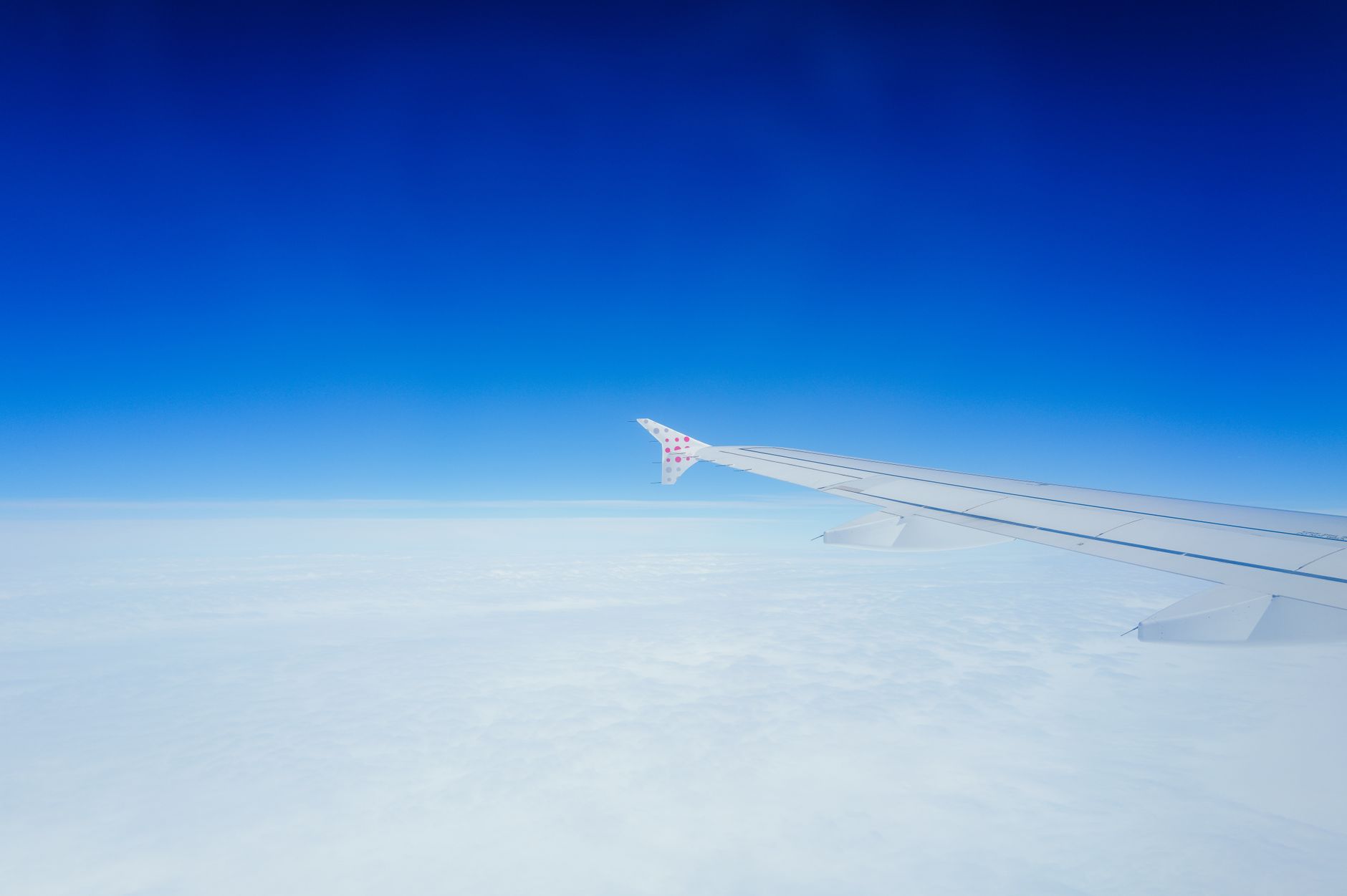 View from an airplane wing above clouds, symbolizing flights from Balkan cities to Türkiye.