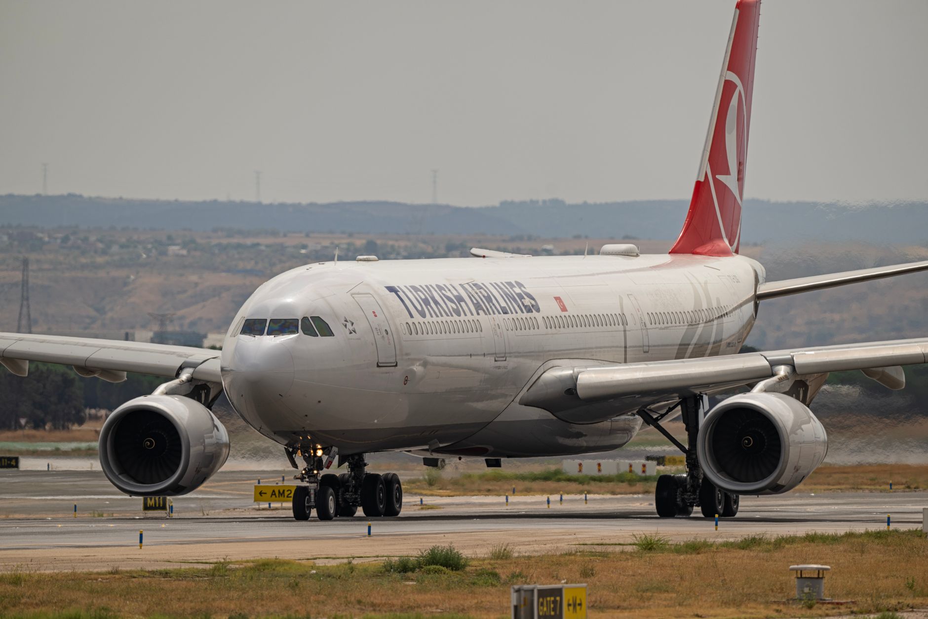 A Turkish Airlines plane taxiing on the runway at a Central Asia airport.